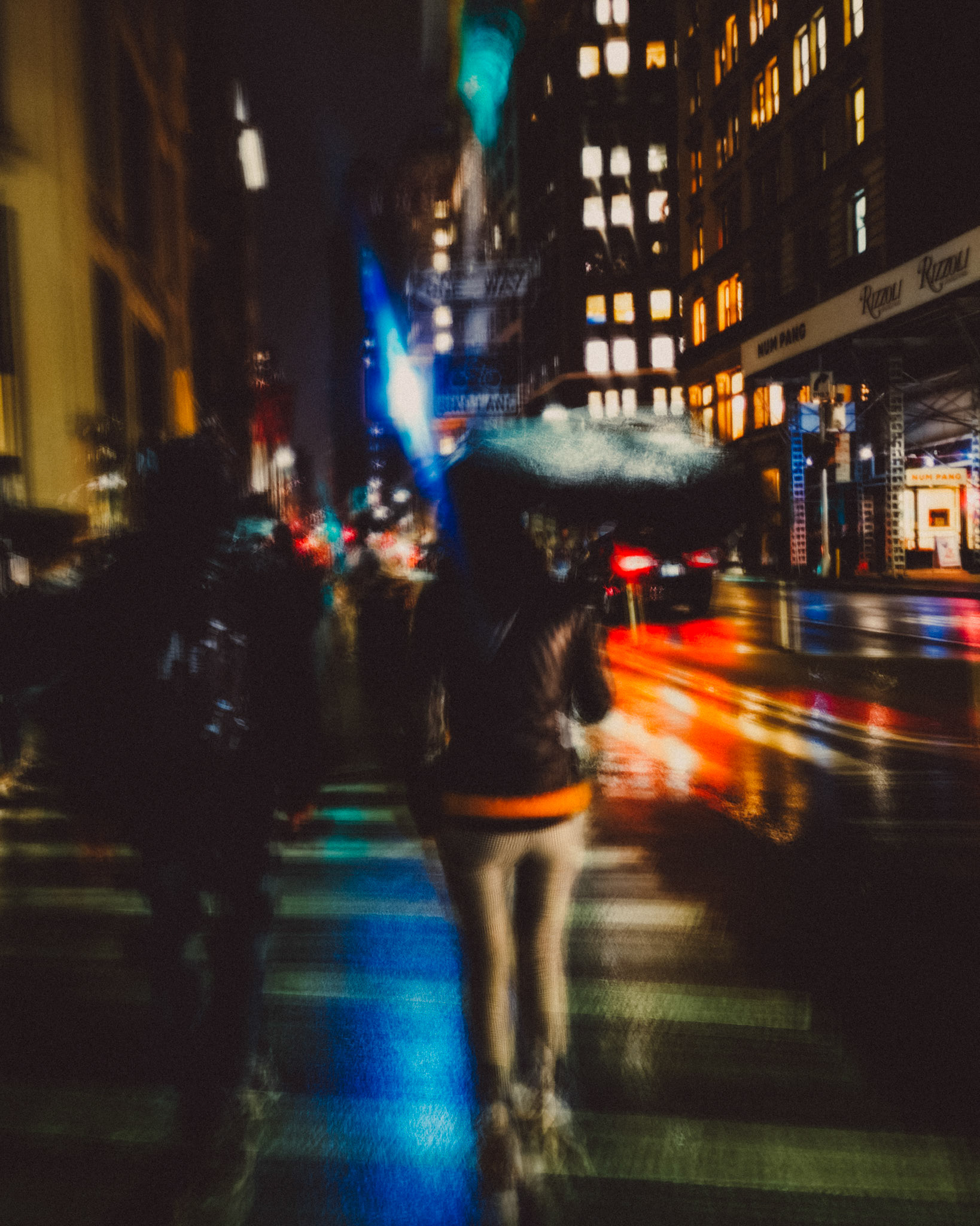 A blurry rainy night shot of a woman holding an umbrella, Manhattan, New York City, USA, November 2019, Huawei P30 Pro.