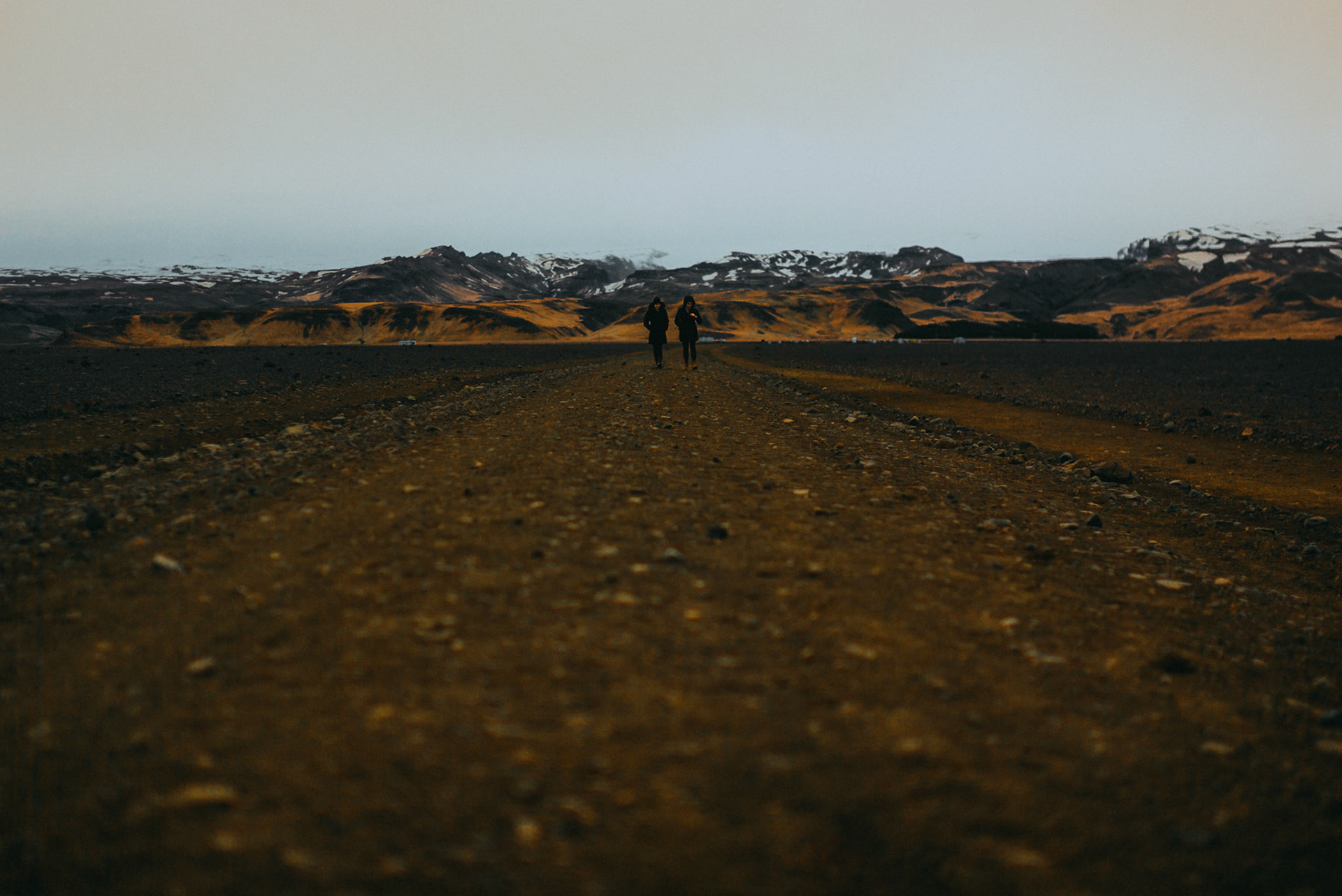Two people walking on a barren landscape towards the Solheimasandur plane crash site, Iceland, May 2016, Leica M.