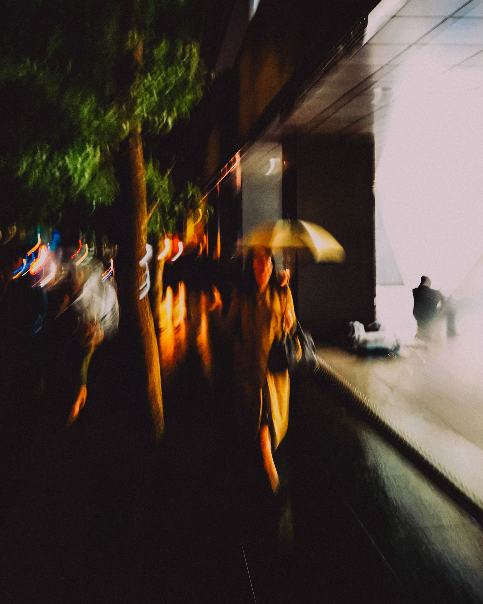 A blurry street snapshot of a woman with an umbrella, Aoyama, Tokyo, Japan, October 2019, Huawei P30 Pro.