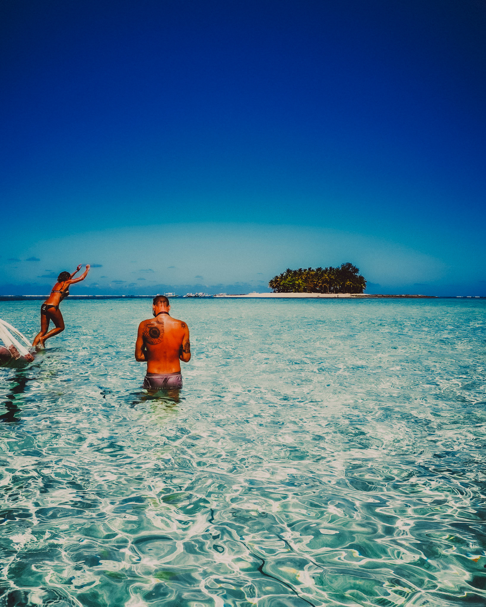 An adventure photo of a couple enjoying Secret Sandbar at lowtide, with Guyam Island in the background, Siargao Island, Philippines, March 2019, Huawei Mate 20 Pro.