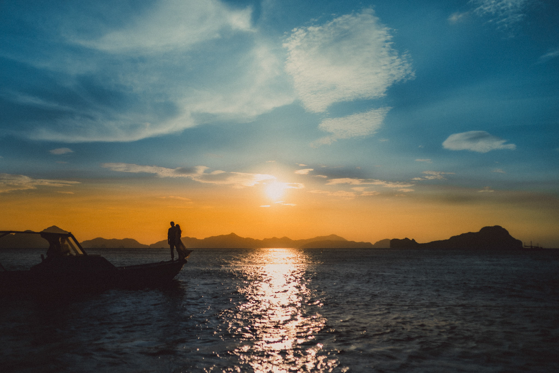 A couple standing on the speedboat's bow for a sunset photo, from Peter &amp; Alexis' adventure engagement in El Nido, Palawan, Philippines, Southeast Asia, April 2018, Sony A7SII
