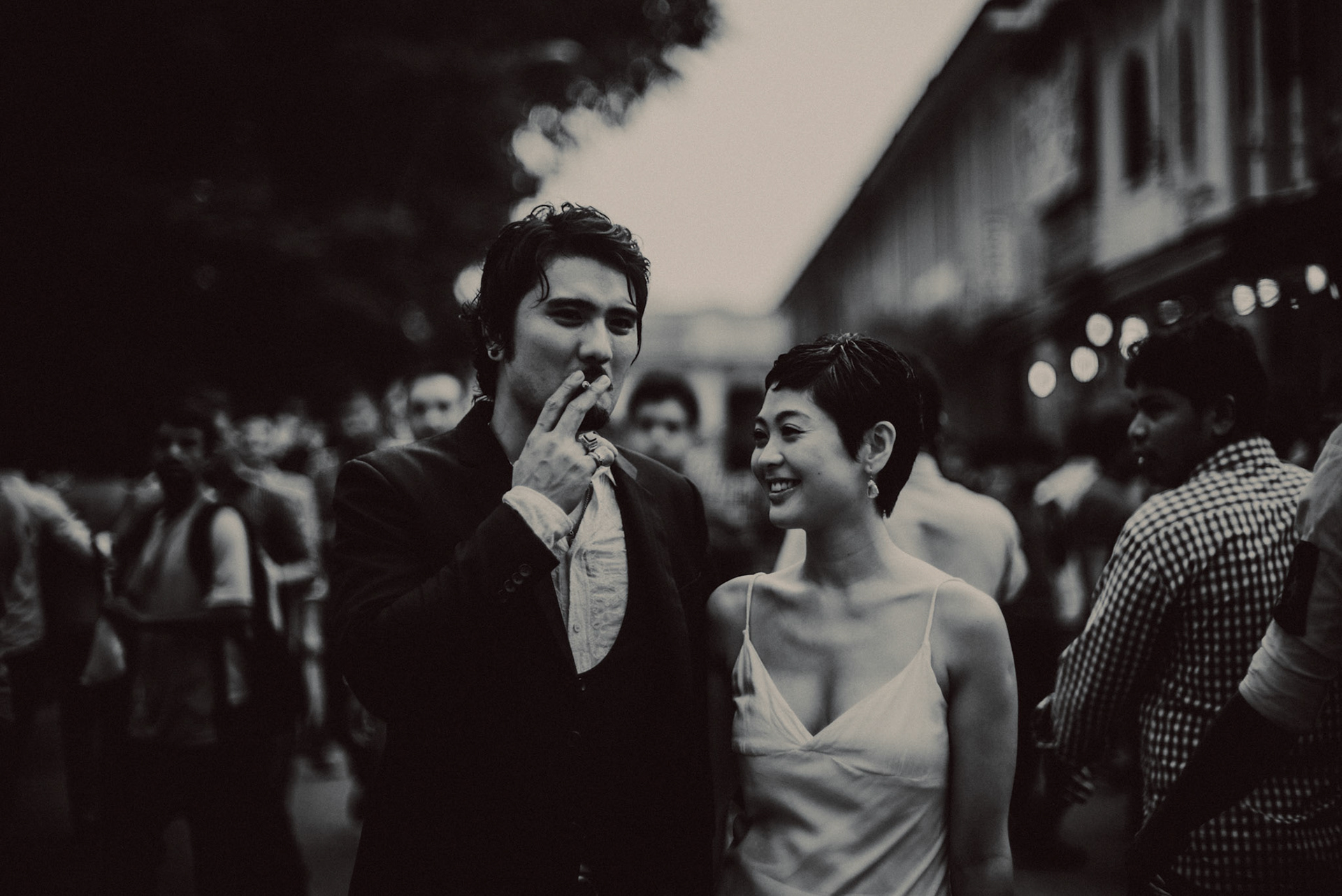 A candid, reportage-style engagement shoot in Little India on a Sunday afternoon feauring a Japanese couple, in black and white, Farrer Park, Singapore, October 2015, Leica M.
