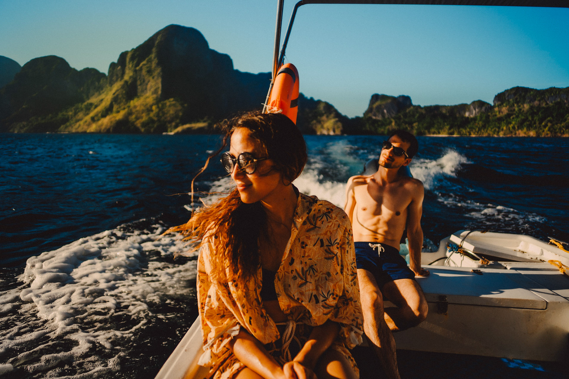 Travel couple portraits on a speed boat during an island hopping tour in Bacuit Bay, with Cadlao Island in the background, El Nido, Palawan, Philippines, Southeast Asia, April 2019, Sony A7III.