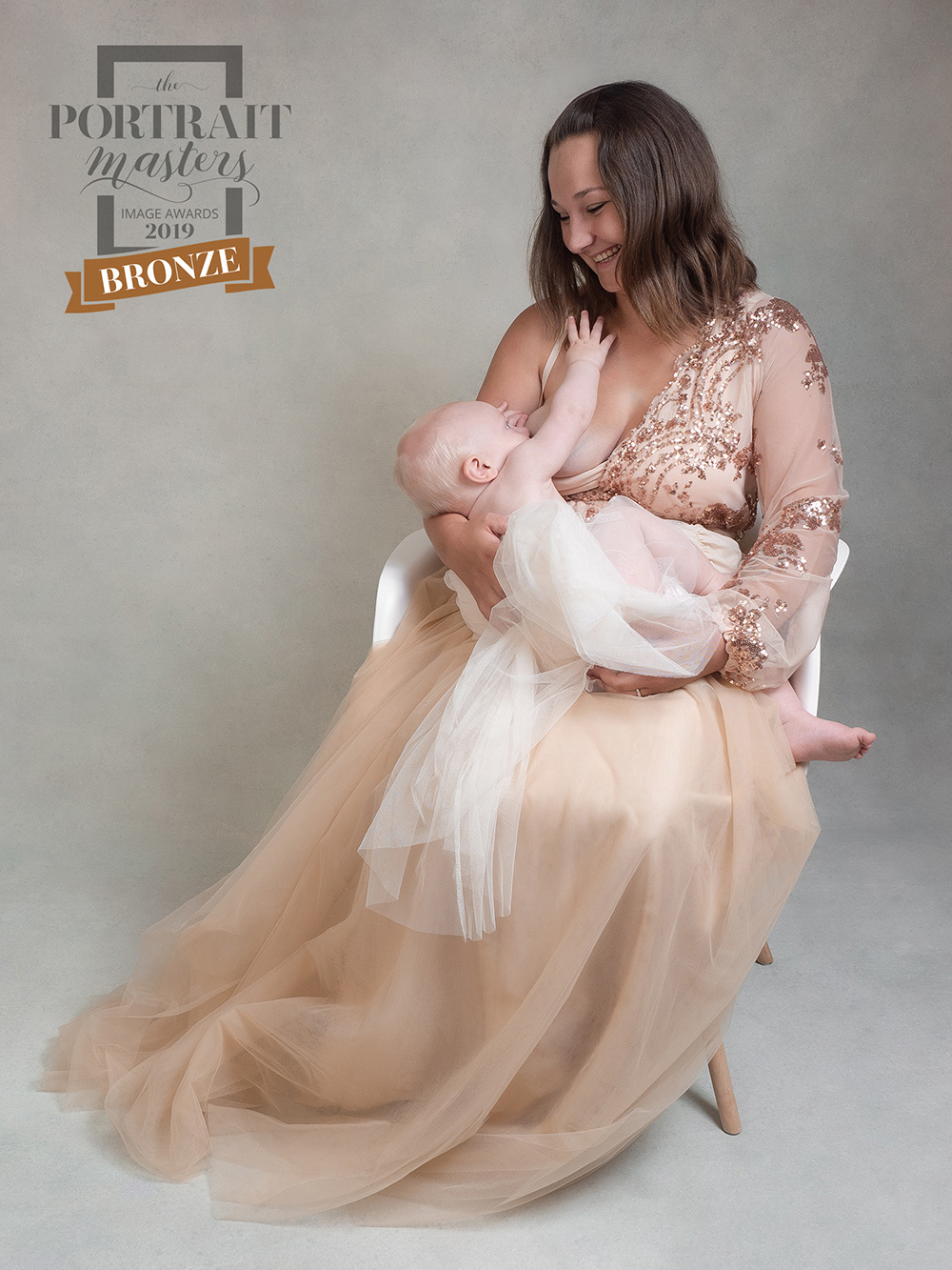 Young mother feeding baby, posed studio photo shoot
