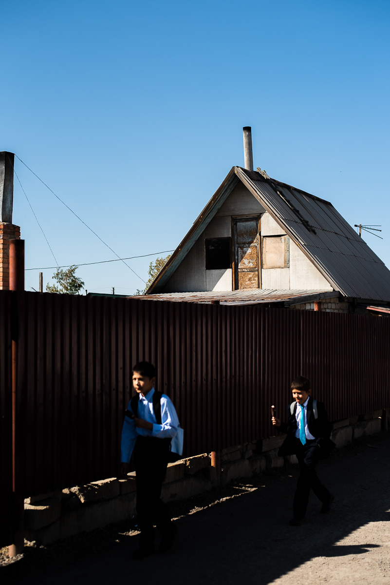 A midi, les écoliers en uniforme courent vers leurs maisons.