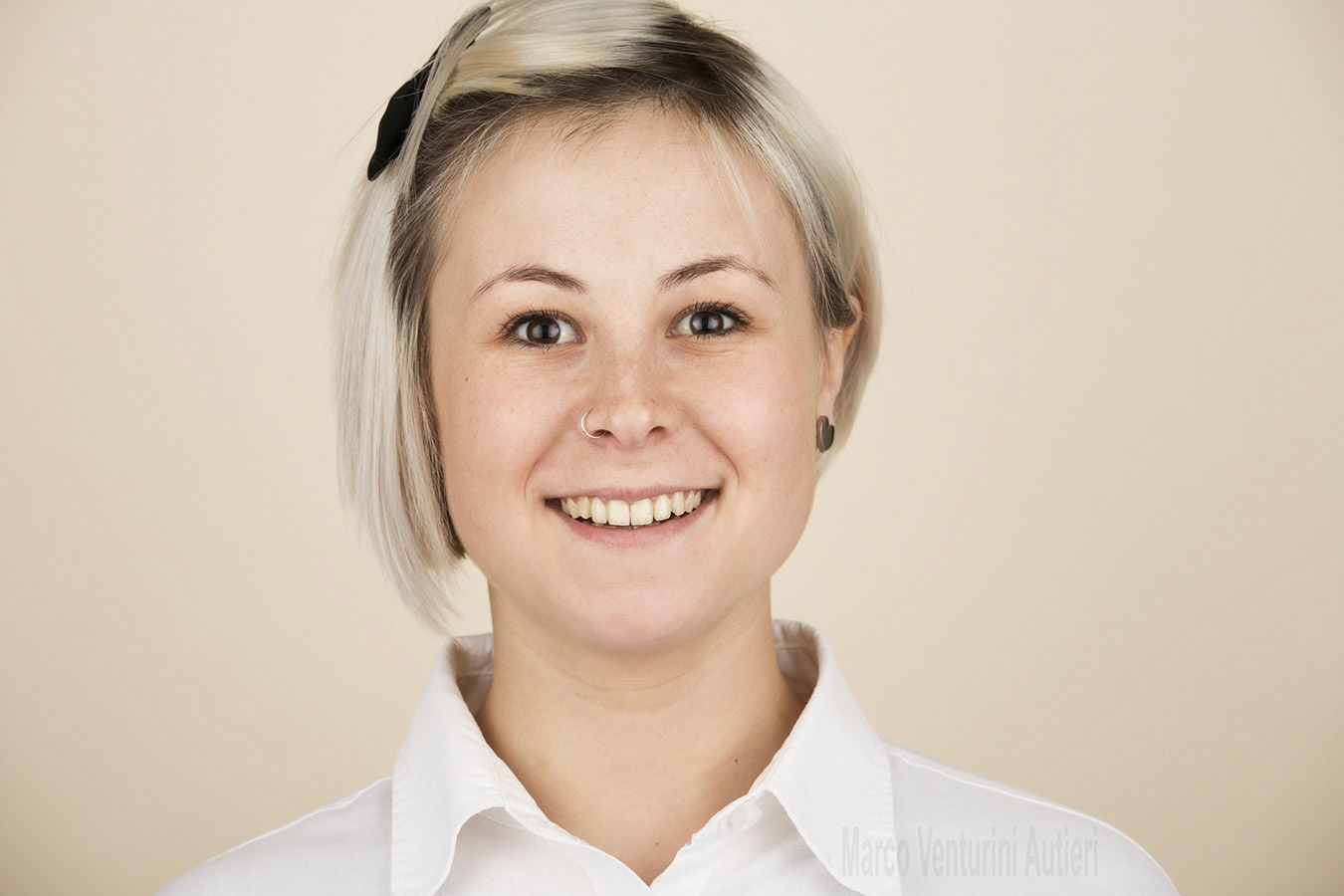 Headshot of young woman posing in the studio on light background