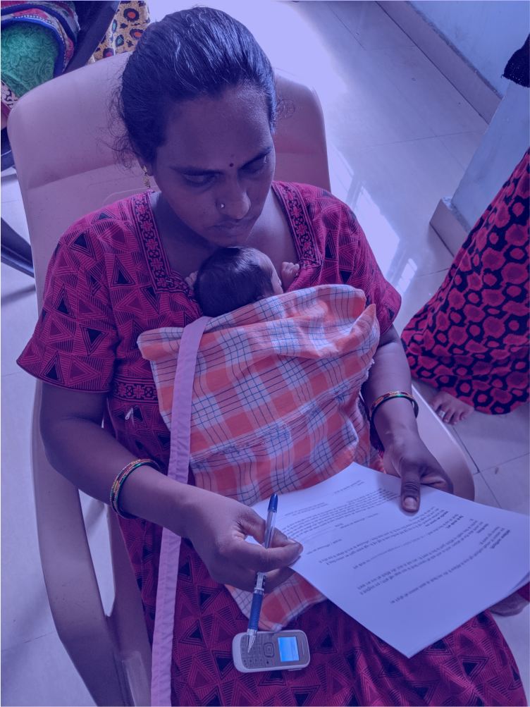 A mother in a hospital in Hyderabad reading and reviewing the consent forms for the study