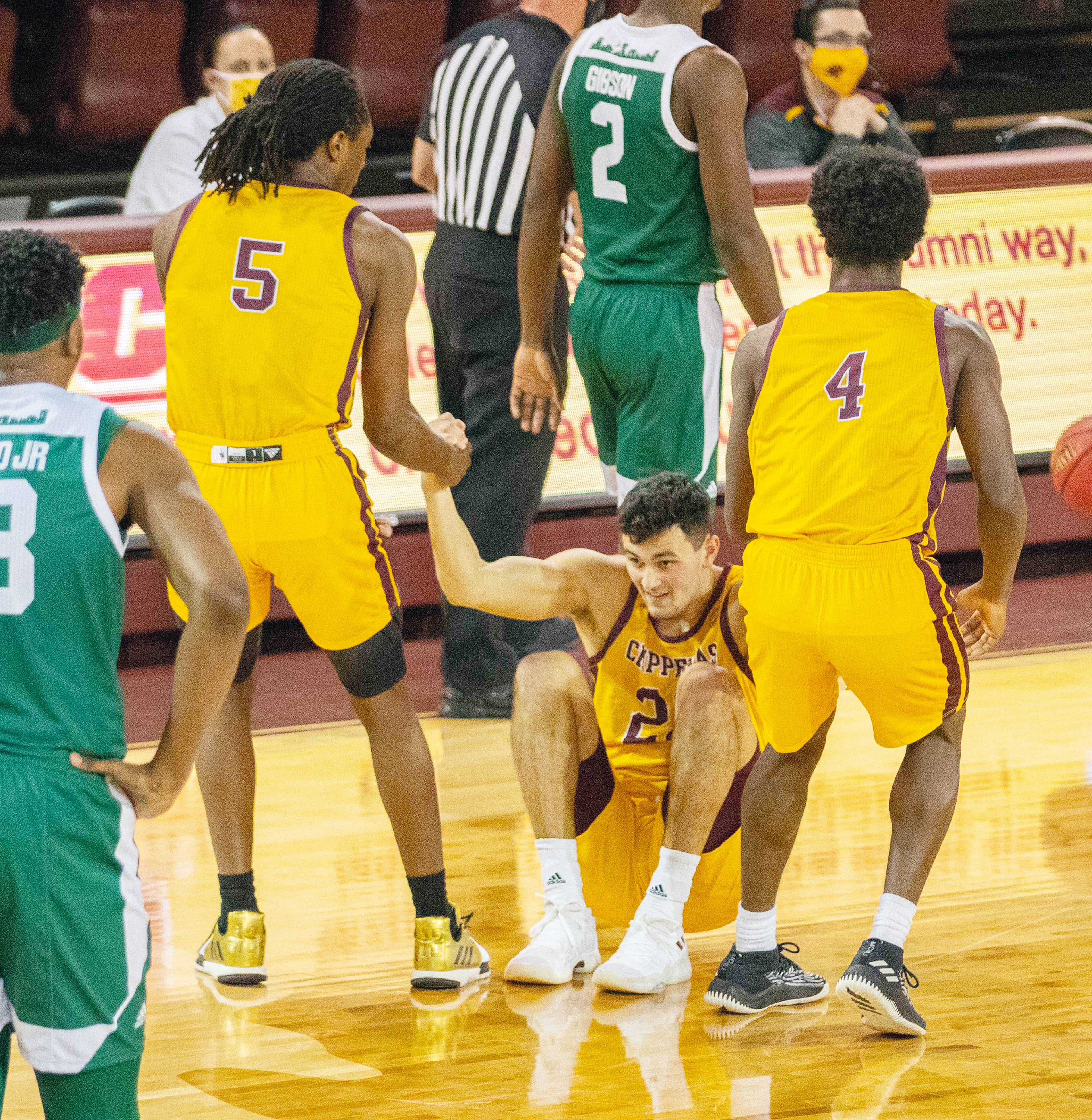 Central Michigan University’s Meikkel Murray, 5, and Caleb Huffman, 4, help Matt Beachler, 22, up after Beachler was fouled by Eastern Michigan University at the Kulhavi Sports Center, on January 16, 2021, on the campus of Central Michigan University.