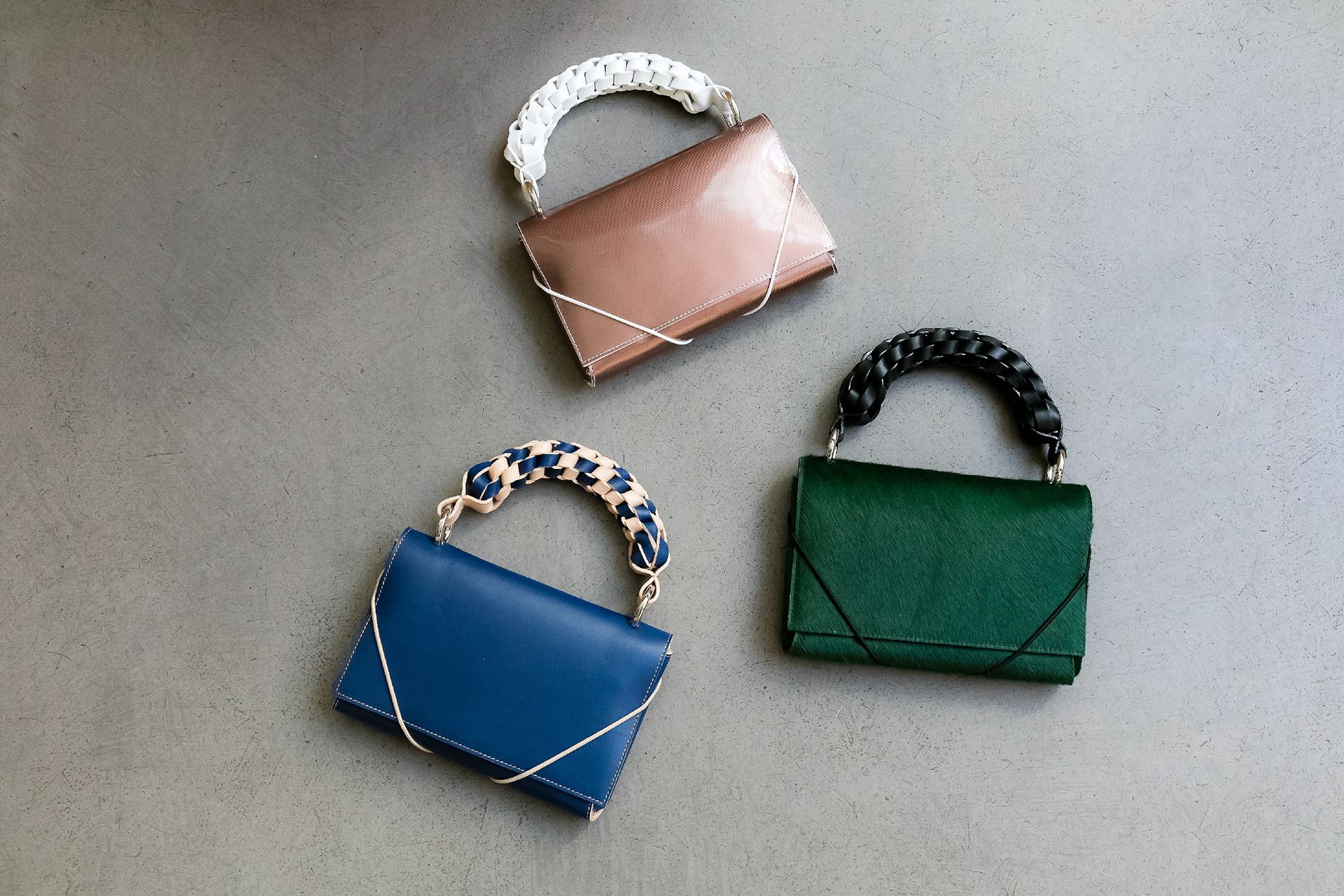 Sac à main BRAIDED avec anse tressée à la main - Dimensions : 16x23x3 cm 260€ 1/ Cuir bleu marine & beige 2/ Poulain vert sapin & cuir lisse noir 3/ Cuir vieux rose irisé & cuir lisse blanc
