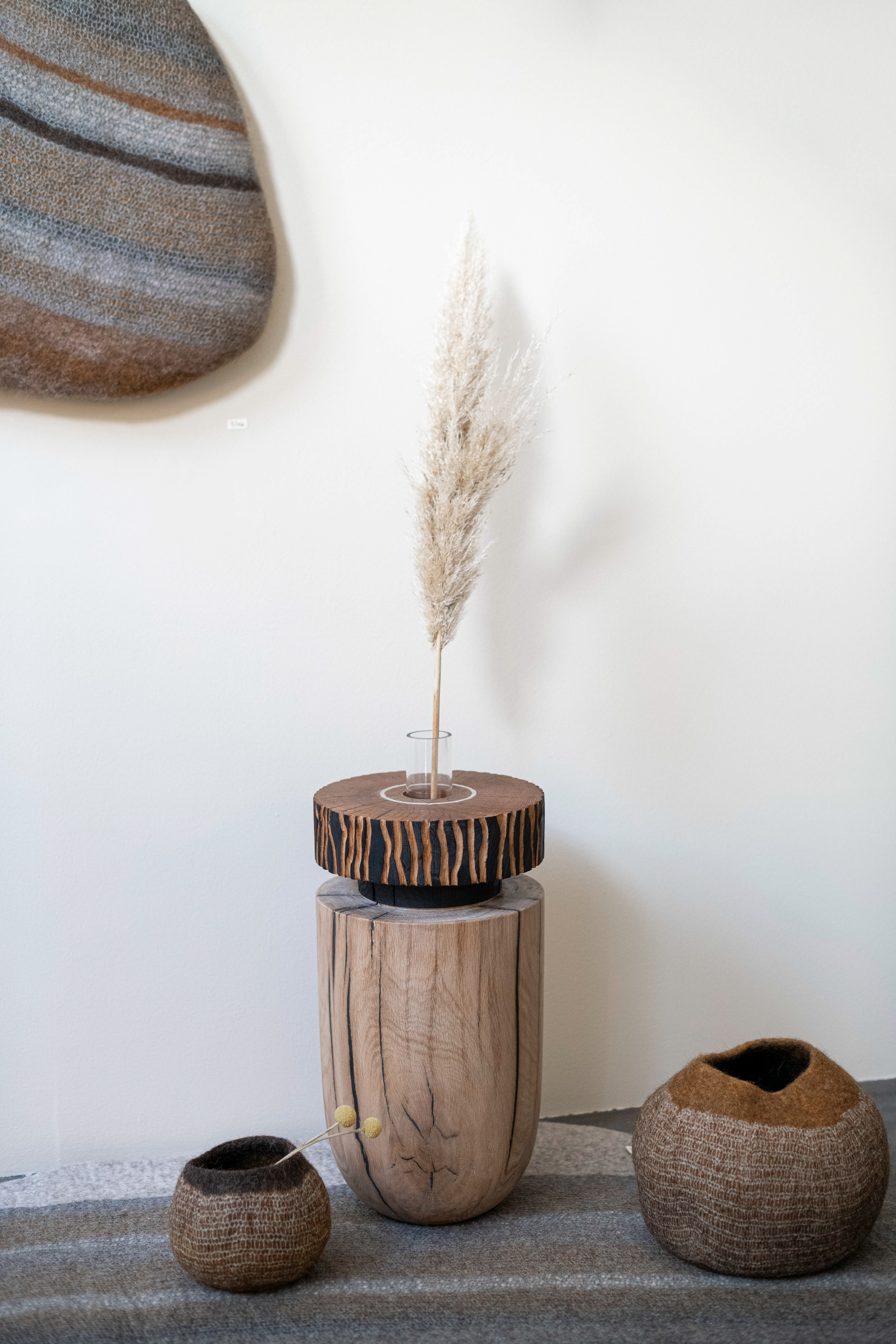 Vase en chêne texturé et brûlé. Un anneau en étain est ajouté sur le dessus. Un tube en verre est inséré permettant l’usage en vase. Diam 14 cm – Haut 43 cm 720€