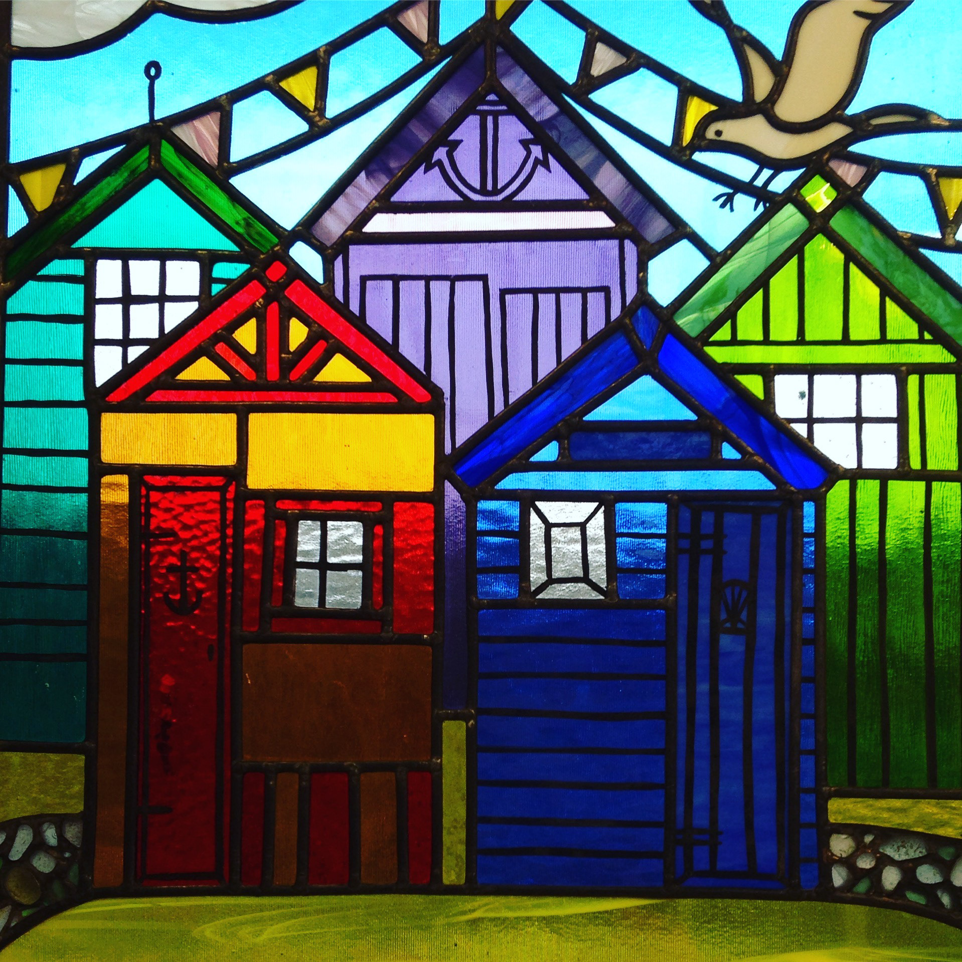 Stained Glass window for York featuring Beach Huts and genuine seaglass pebbles. Made by Zoe Eady of the Glass Garden - a Stained Glass Artist from Leeds UK.