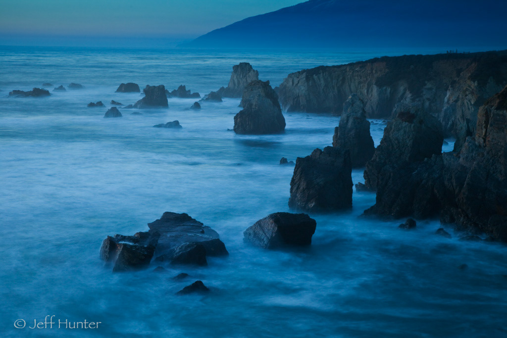 A dramatic rocky coastline at dusk