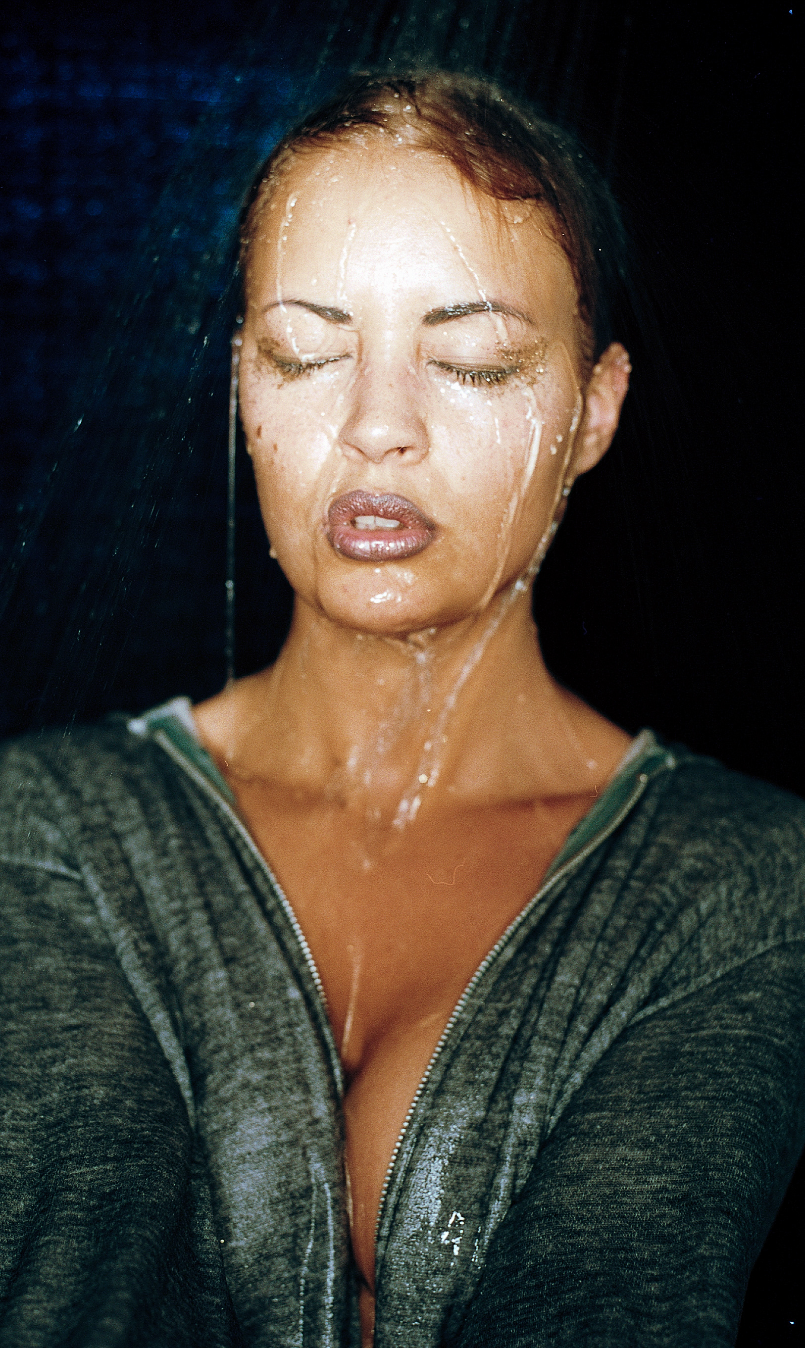 Caucasian woman, eyes closed with water streaming down her face