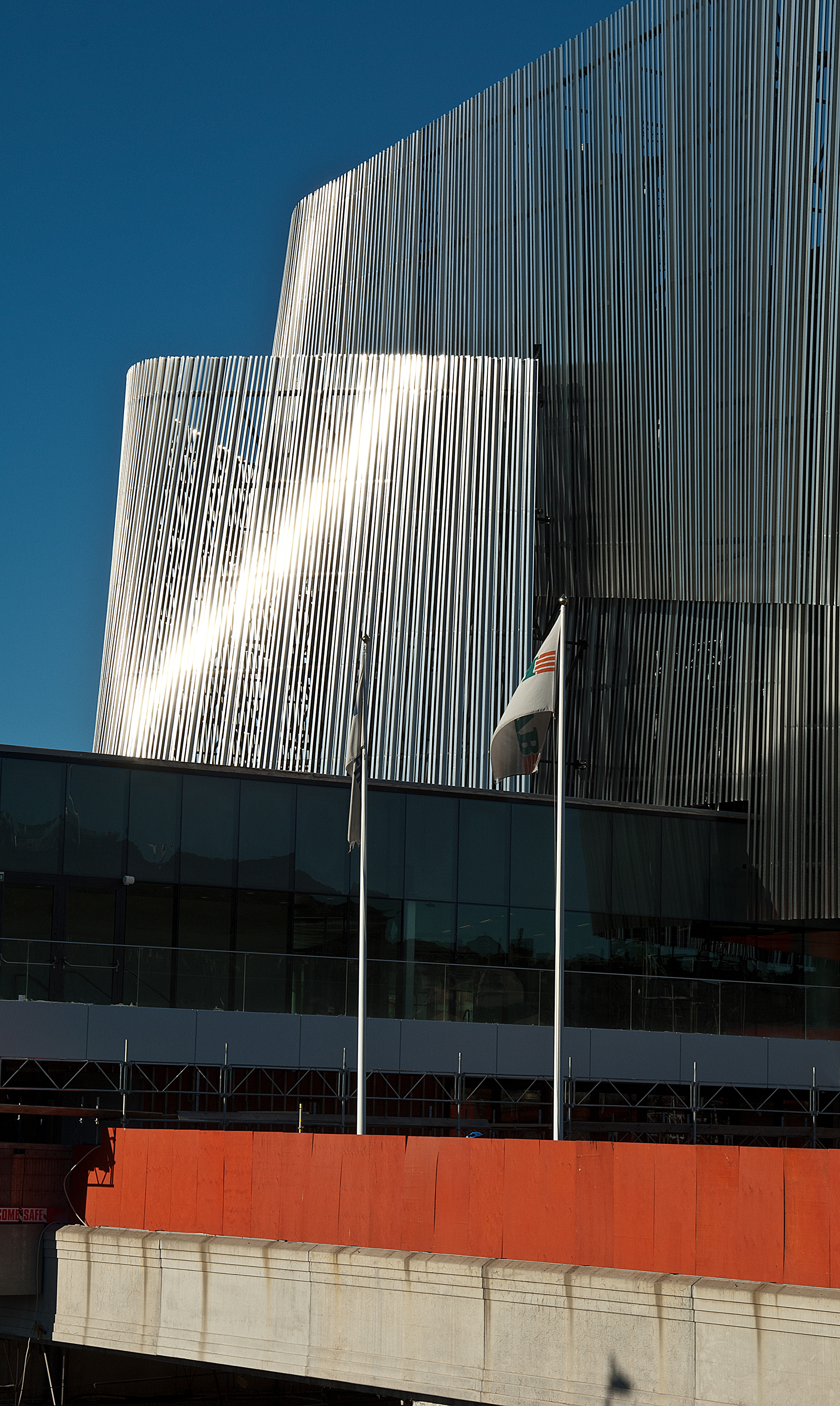 Facade of the stockholm waterfront congress center with a red wooden fence in front ofnt