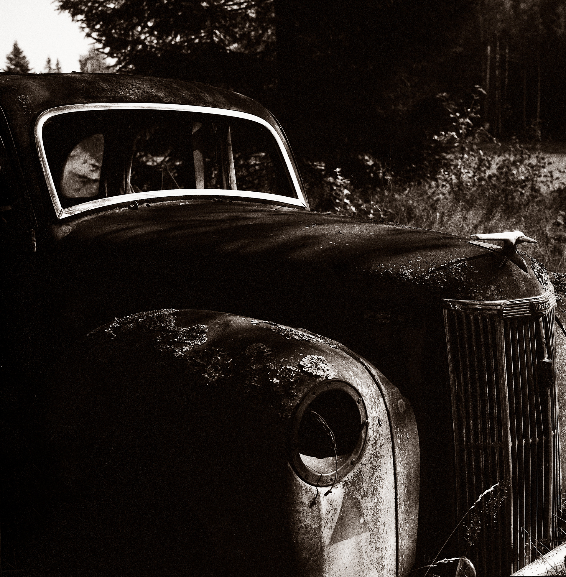 Front of vintage decaying Ford Prefect, black and white