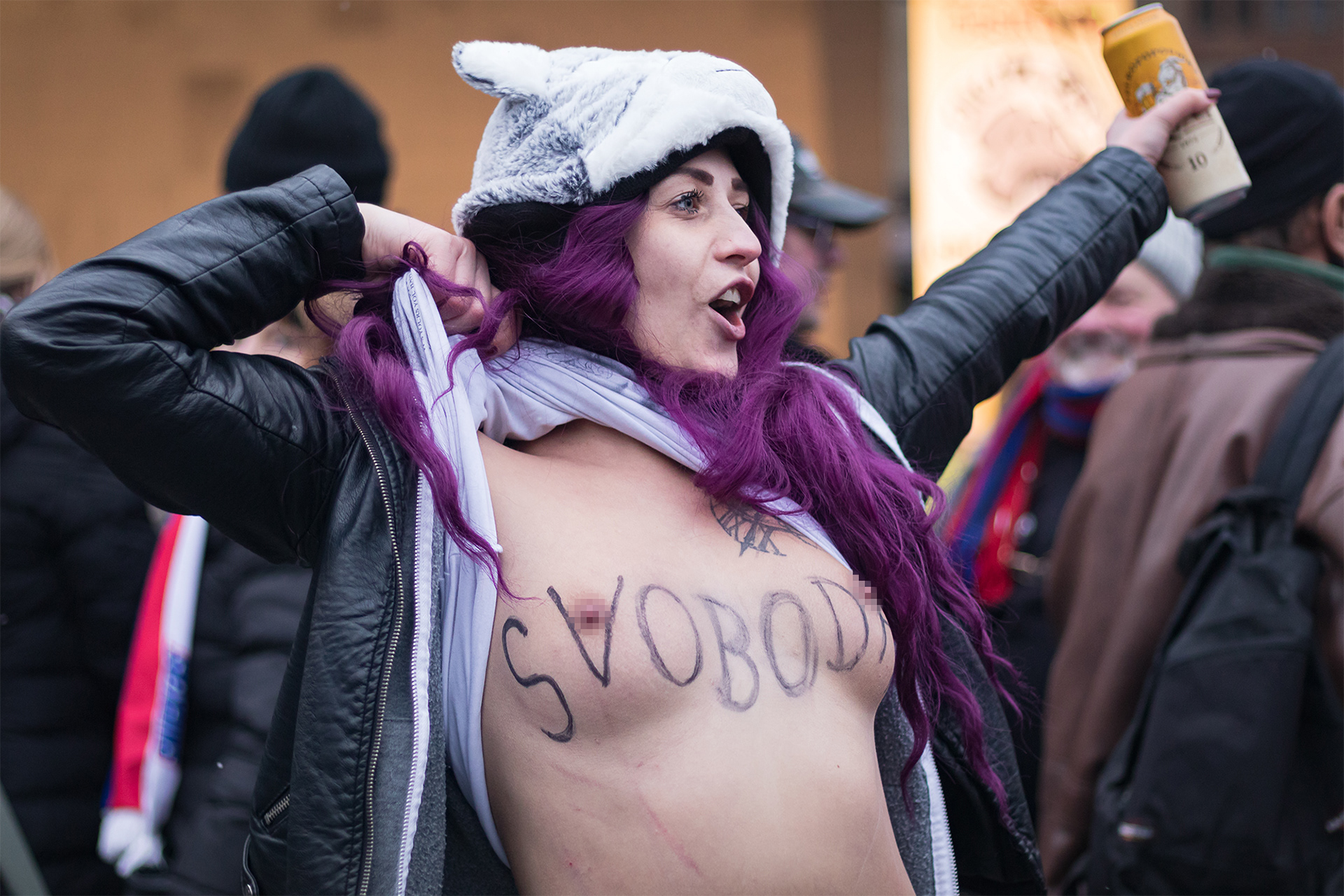 Reportážní fotografie jedné z demonstrujících odhalující svá prsa s nápisem "Svoboda" při demonstracích na Staroměstském náměstí v Praze