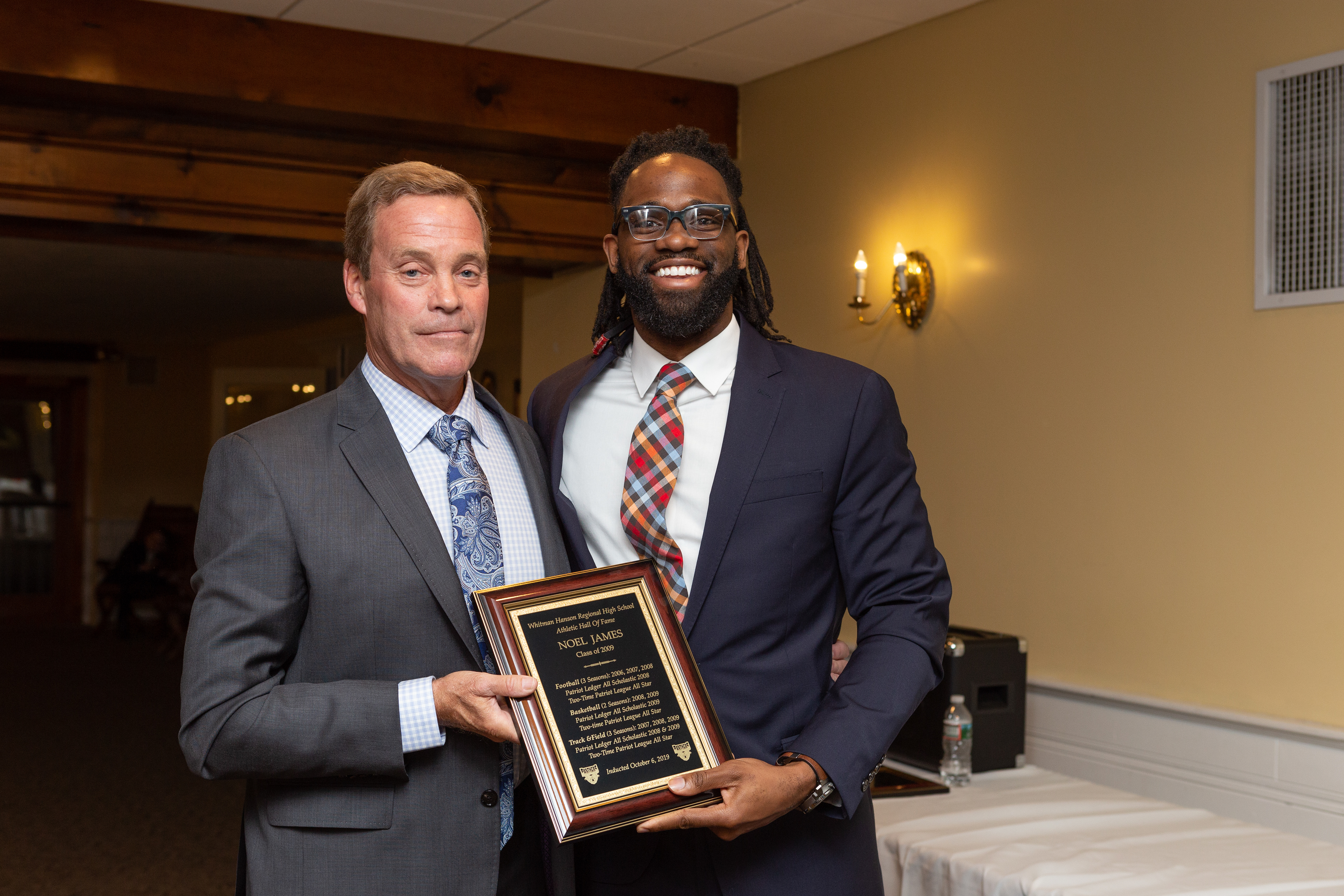 Kevin Black (left) and Noel James (right) pose and present James' induction award. Noel credits his success to the efforts of staff and faculty that pushed him, those including Black. Photo by Austin Schofield.