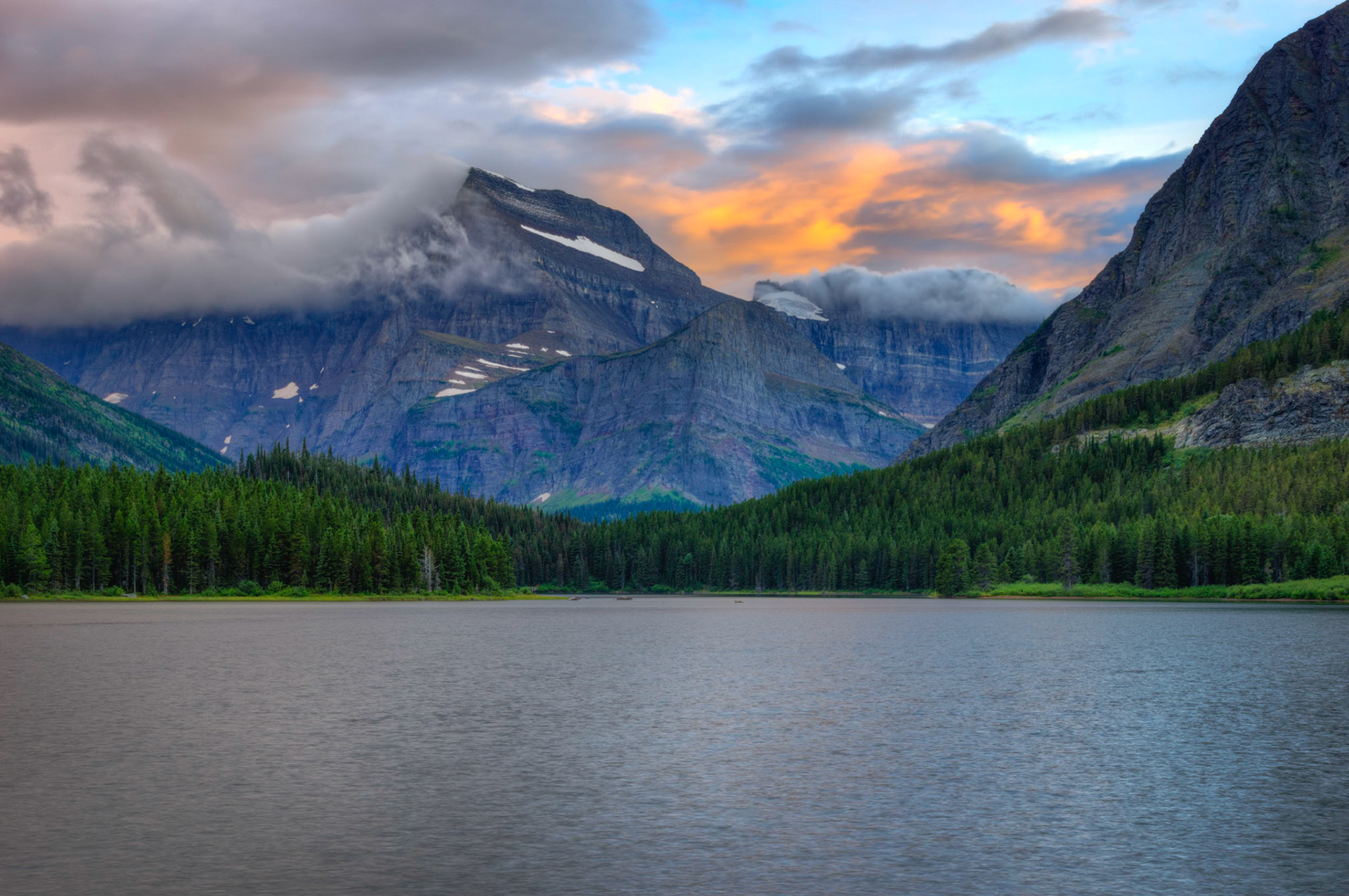 A receding storm still clinging to the peak of Mt. Gould, leaving behind a bit of fresh snow.  In the foreground is Swiftcurrent Lake, and the small peak slightly right of center is Angel Wing.  Above that is Gem Glacier.Glacier National ParkJuly 27, 2015This is an HDR image consisting of 5 exposures merged in Photomatix Pro. Additional processing in Lightroom and Photoshop.PENTAX K-3, Sigma 18-250mm f/3.5-6.3 DC OS HSMISO 100 37 mm  0.4 sec at ƒ / 11