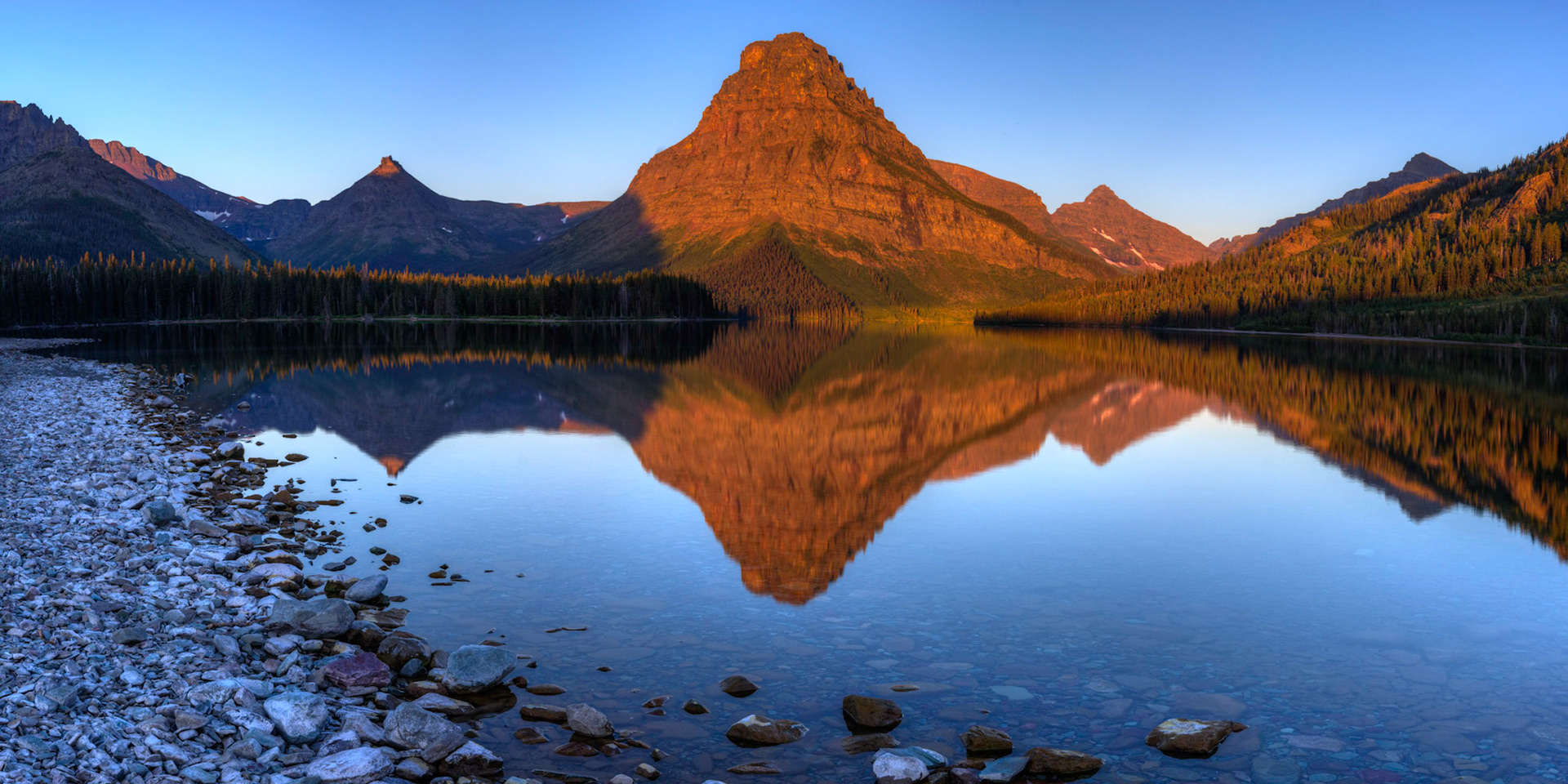 Sunrise on a still morning at Two Medicine Lake.Glacier National ParkJuly 30, 2015This is an HDR panoramic image consisting of 6 frames comprised of 5 exposures each. HDR processing performed in Photomatix Pro.  Panoramic stitching performed in Photoshop. Additional processing performed in Lightroom and Photoshop.PENTAX K-3, Sigma 18-35mm f/1.8 DC HSM ArtISO 100 26 mm  ¼ sec at ƒ / 11