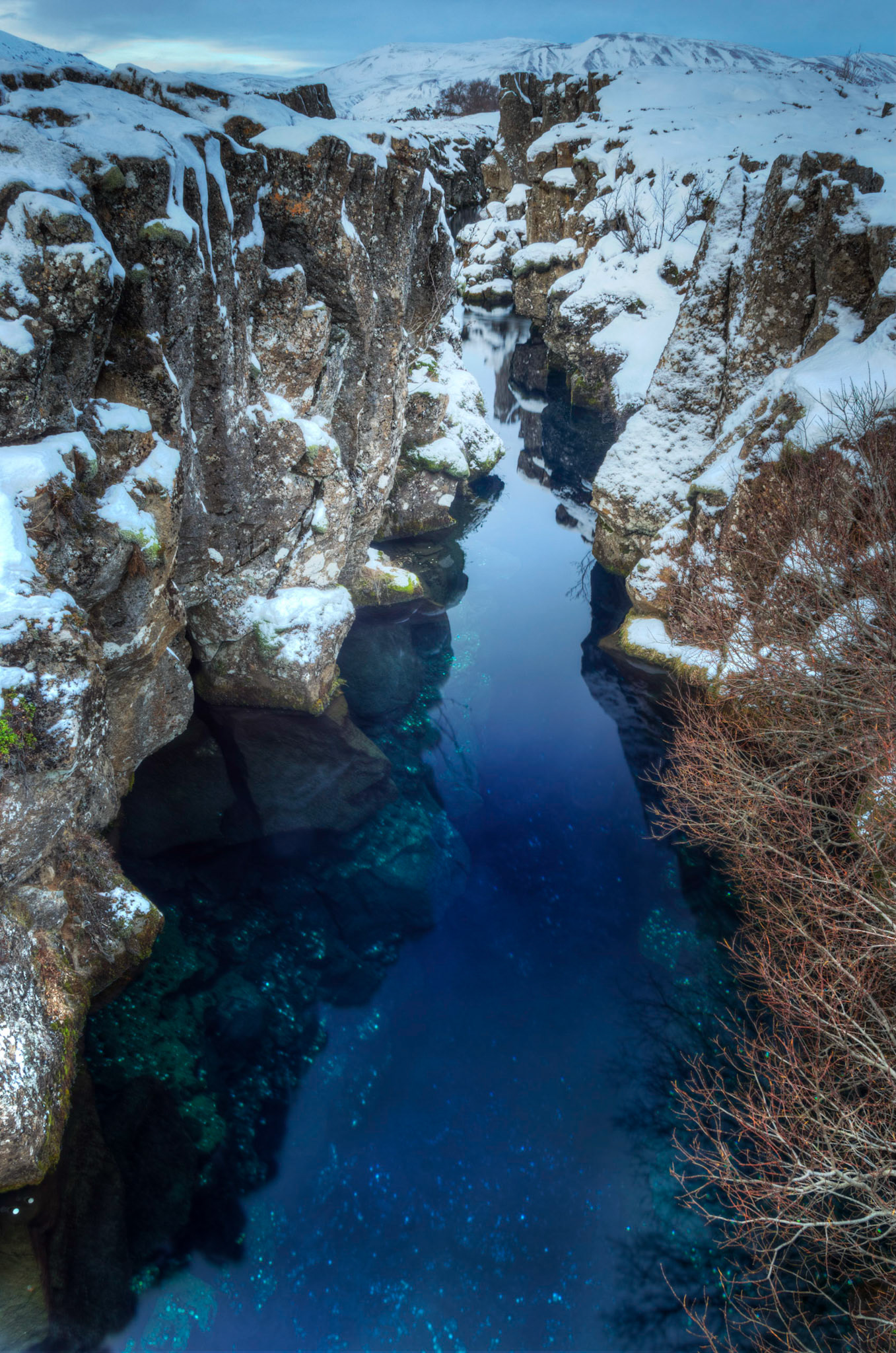 The rift between the North American and Eurasian tectonic plates.  This is Peningagjá, where visitors have thrown coins into the water following European tradition.Þingvellir National ParkFebruary 7, 2016This is an HDR image consisting of 10 exposures merged in Photomatix Pro. Additional processing in Lightroom and Photoshop.PENTAX K-3, Sigma 18-250mm f/3.5-6.3 DC OS HSMISO 100 18 mm  3.0 sec at ƒ / 13