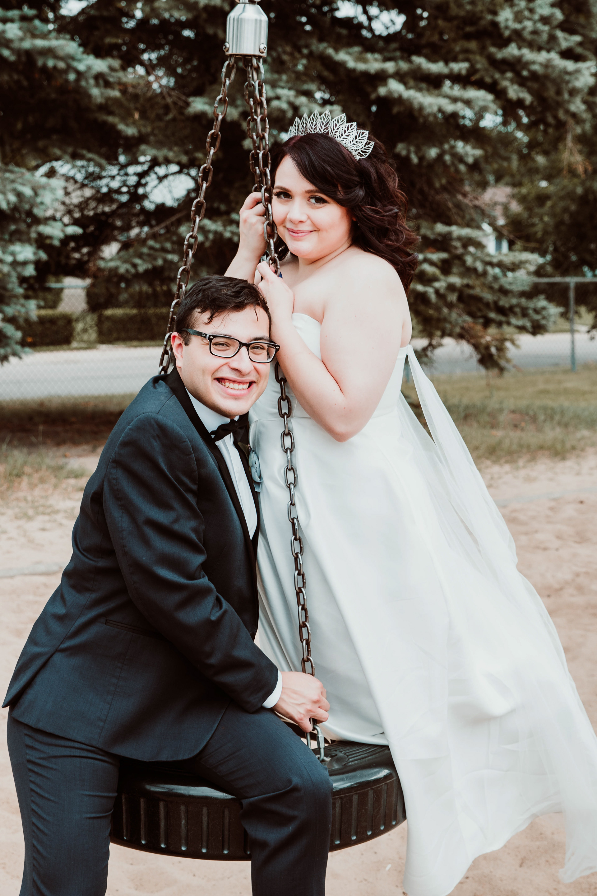 Bride and groom in the summer on a tire swing in Edmonton