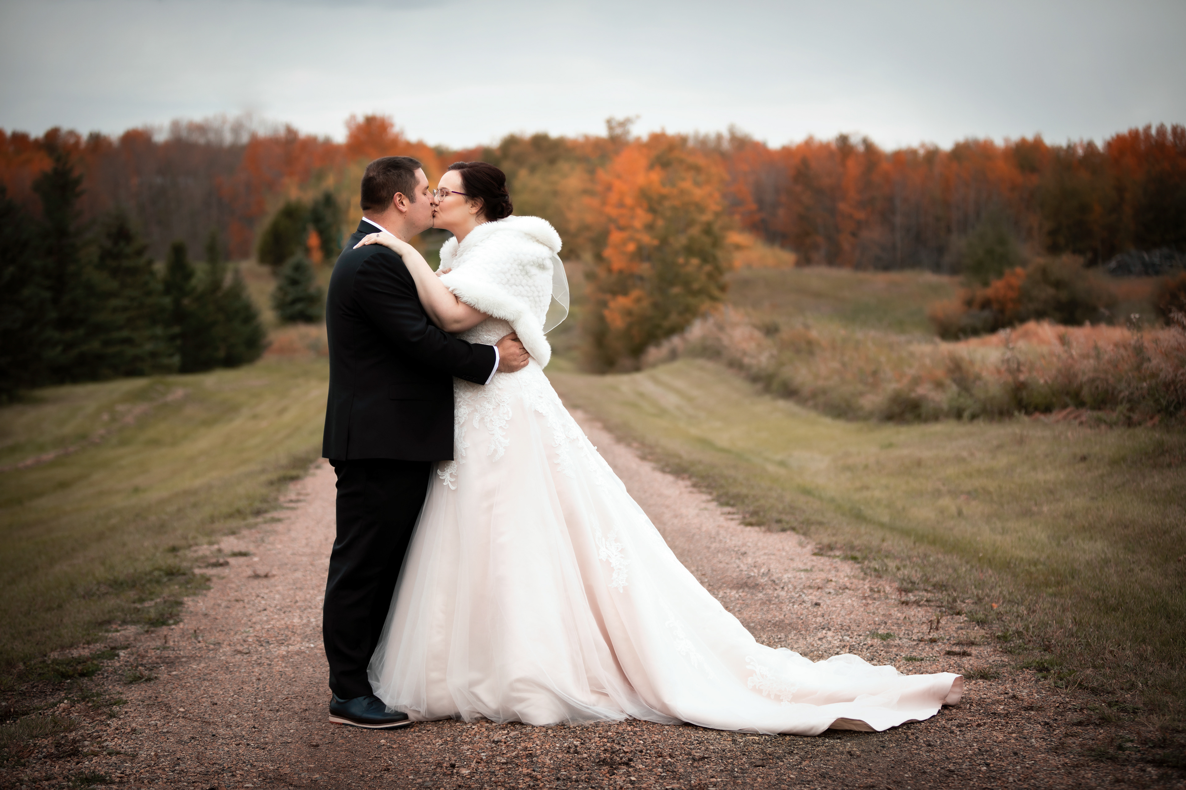 Bride and groom kissing in fall of Edmonton