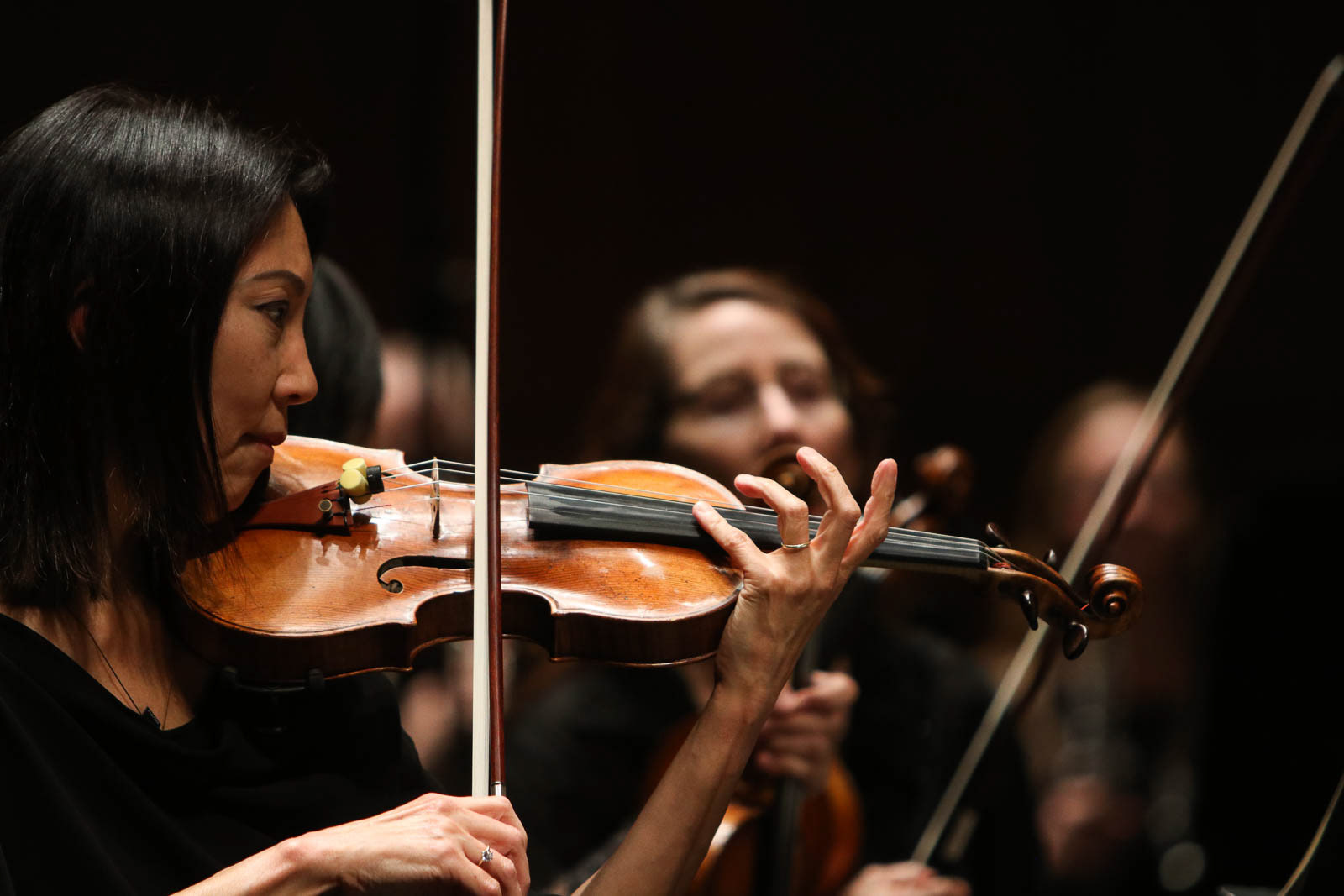 Woman plays violin in orchestra during an Oregon Bach Festival performance