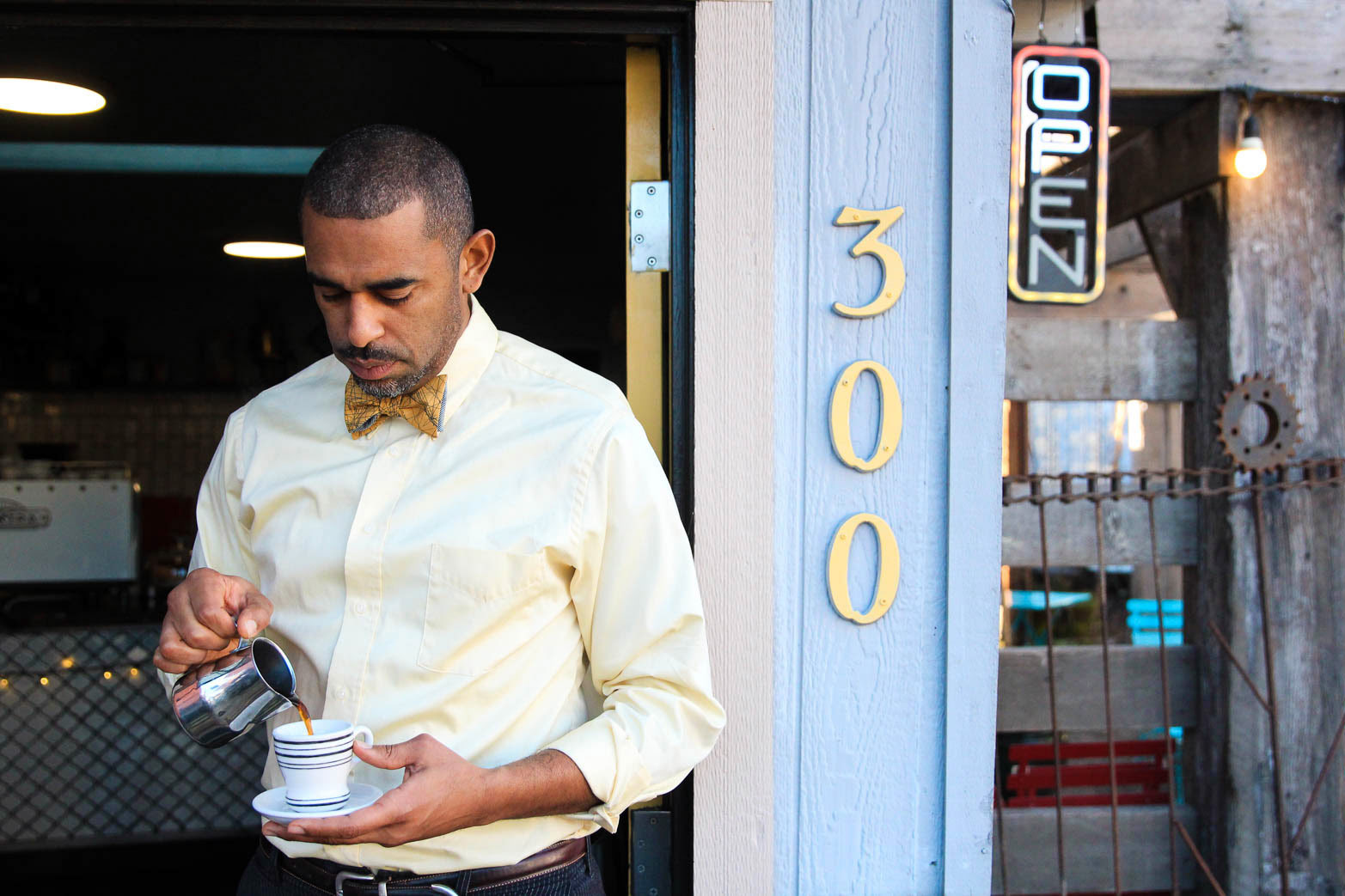 Small business owner and coffeeshop operator pours a cup of coffee outside of Equiano
