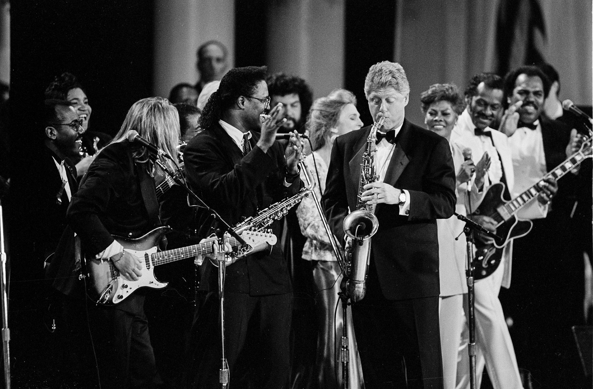President Clinton, playing saxophone at the Arkansas ball, was joined by, from left, Everette Harp, clapping, Judy Collins, Dionne Warwick, and Chuck Berry, January 20, 1993.