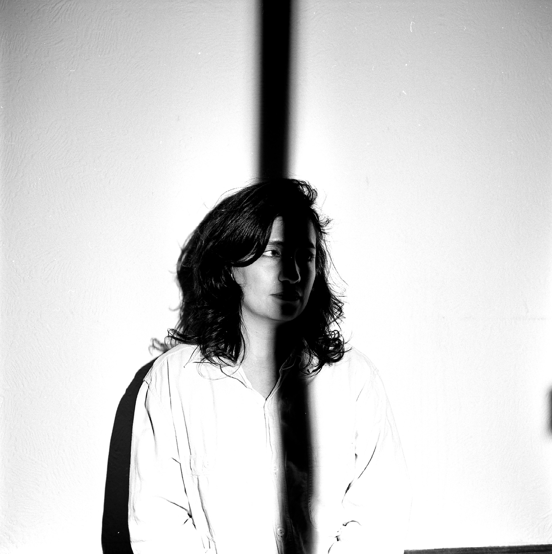 the female model looks to camera right, some of her face is obscured by shadow, hiding all detail