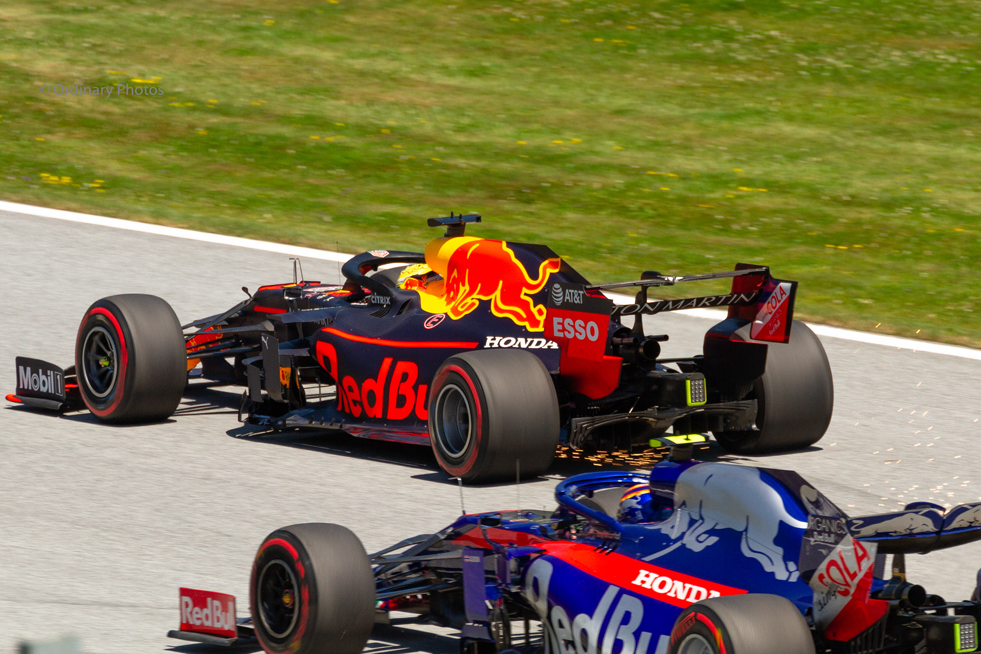 Max Verstappen in de Red Bull samen met Alex Albon in de Toro Rosso op het circuit in Oostenrijk in 2019