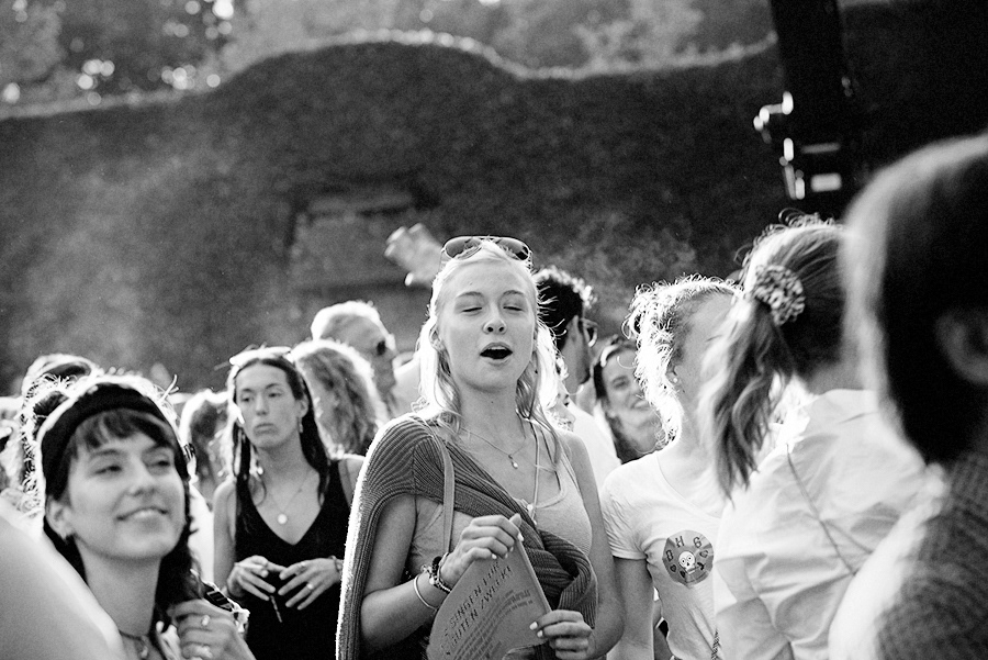 fröhlich singende frau im publikum in der sonne