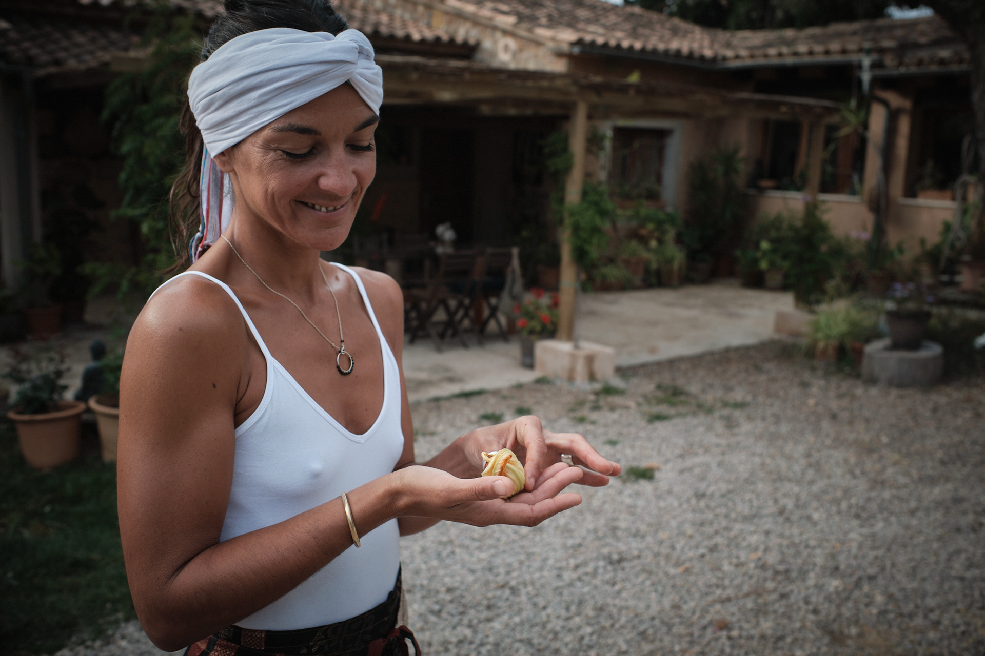 Laura observando una flor de calabaza de su huerto