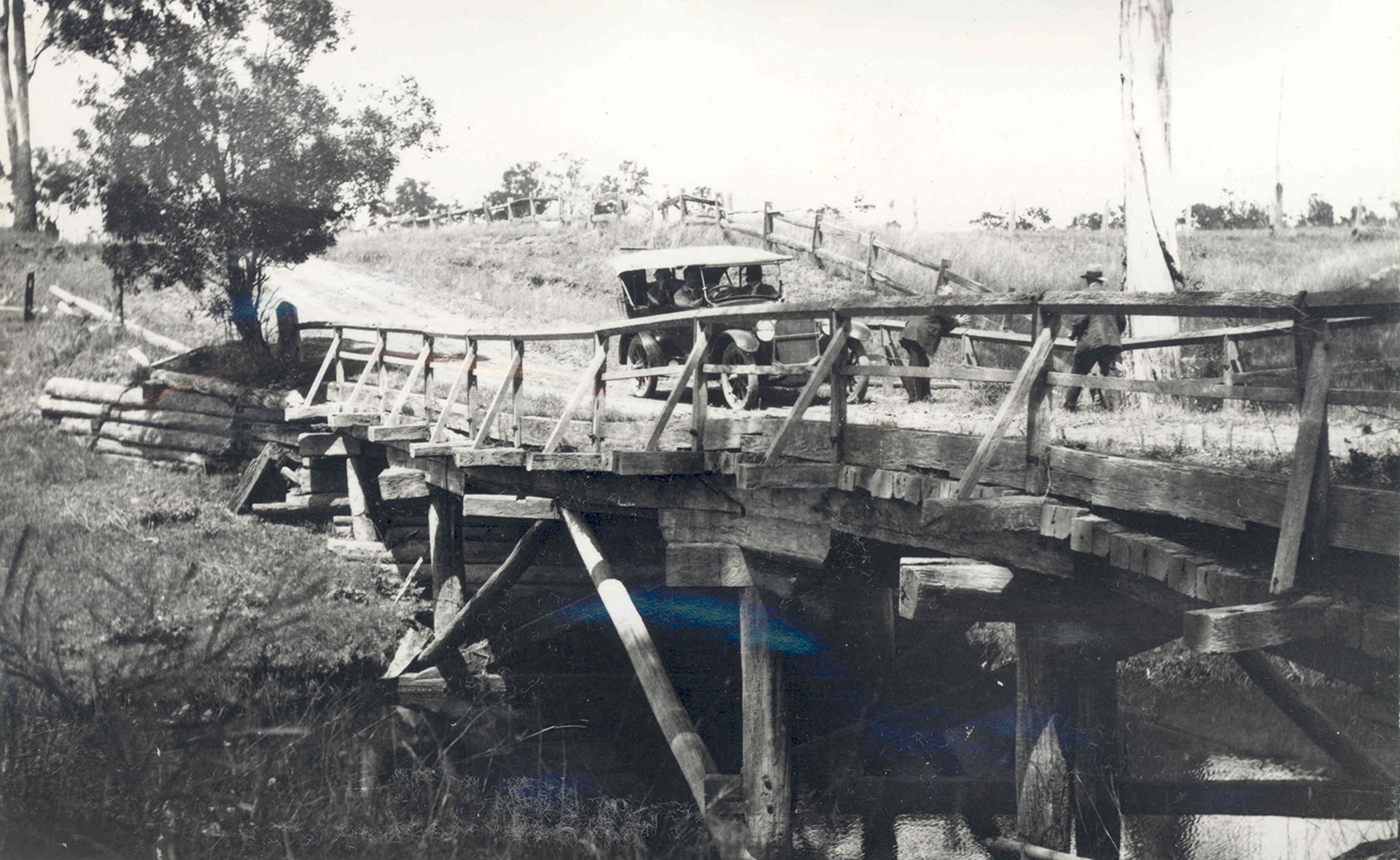 Crossing timber bridge, Vintage car driving across wooden bridge. Low cost road