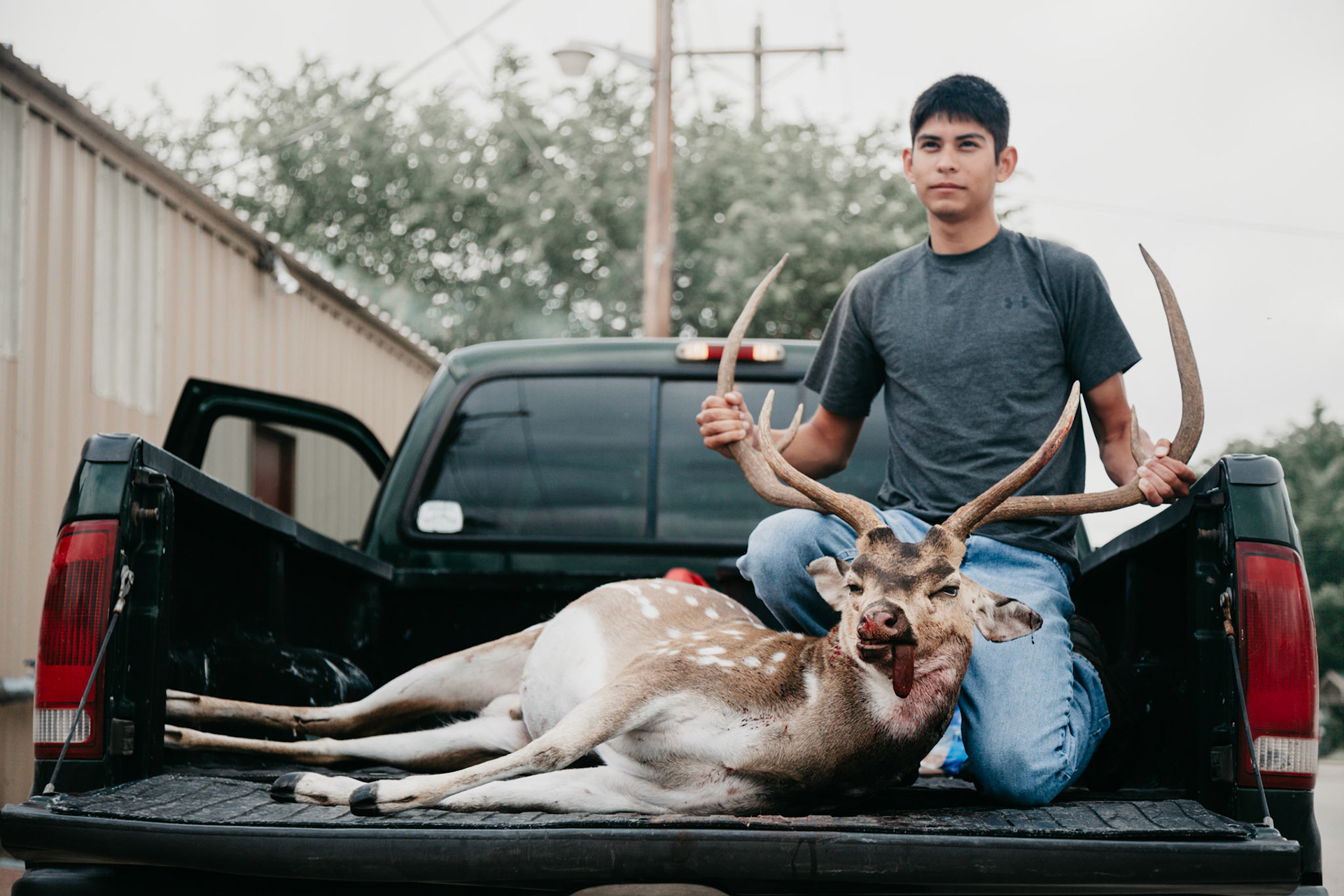 A hunter proudly displays his trophy outside a Junction, Texas rendering plant.