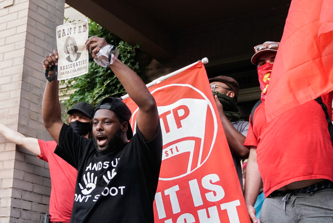 Protestors stand outside St. Louis Mayor Lyda Krewson's house during a protest in the Central West End on Sunday, June 28, 2020. Protestors called for the mayor to resign after she read the names and addresses of people wanting to defund the police in St. Louis out loud during a Facebook livestream.