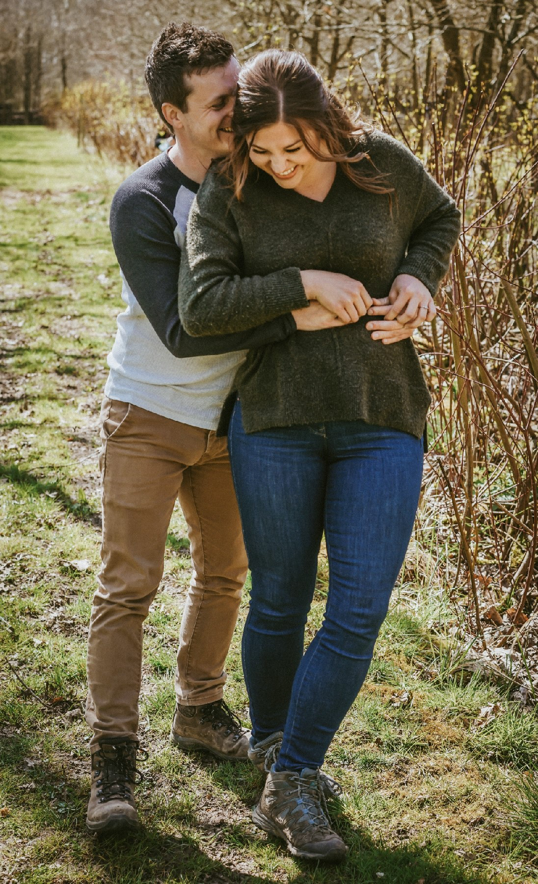 cute cuddle from behind from soon to be groom with bride at endeavour woodland wedding venue near winslow in buckinghamshire uk at pre wedding engagement session with david lefebvre a photographer from milton keynes