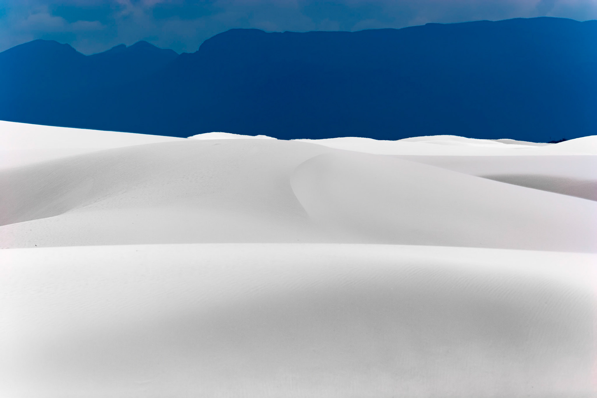 White Sands National Monument, New Mexico. Rising from the heart of the Tularosa Basin is one of the world's great natural wonders - the glistening white sands of New Mexico. Great wave-like dunes of gypsum sand have engulfed 275 square miles of desert, creating the world's largest gypsum dunefield. White Sands National Monument preserves a major portion of this unique dunefield, along with the plants and animals that live here.