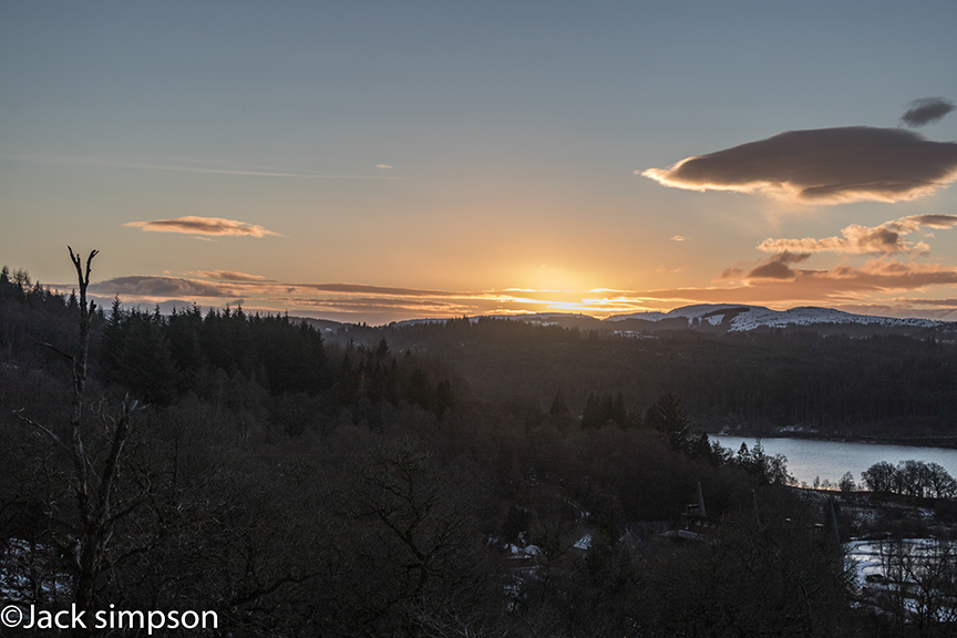 Early morning shot of dawn or sunrise over the trossach hills with loch venacher in the middle ground. The photograph was taken from the lower slopes of Ben An. The clouds look almost like space ships!