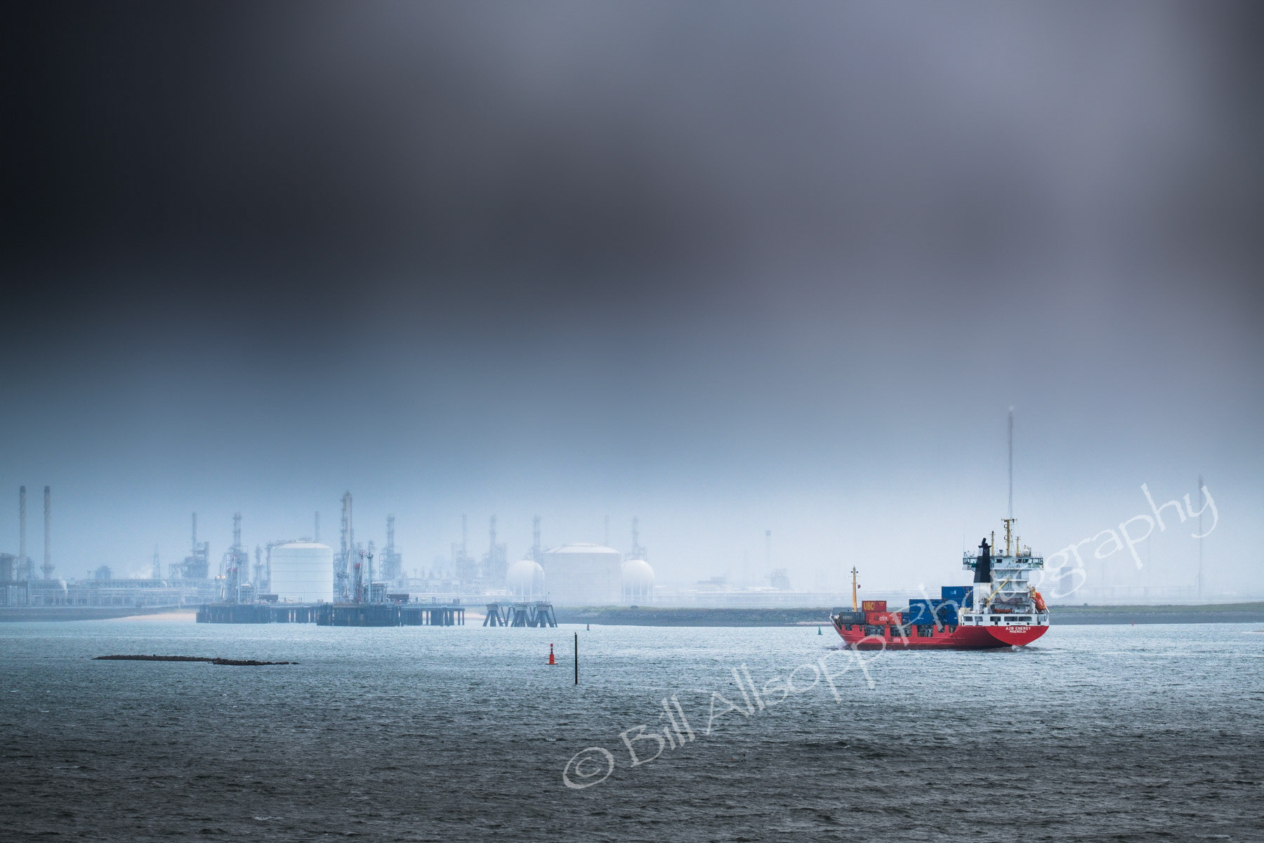 A container ship heading up the Tees during a storm.