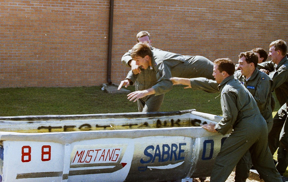 We suspect Aaron may have been the first in our class to solo in the T-37 because the class number and flight names painted on the dunk tank are those of the class ahead of ours. According to UPT etiquette, our class could not decorate the dunk tank with our class colors and flight names until all students in the class ahead of ours had soloed.
