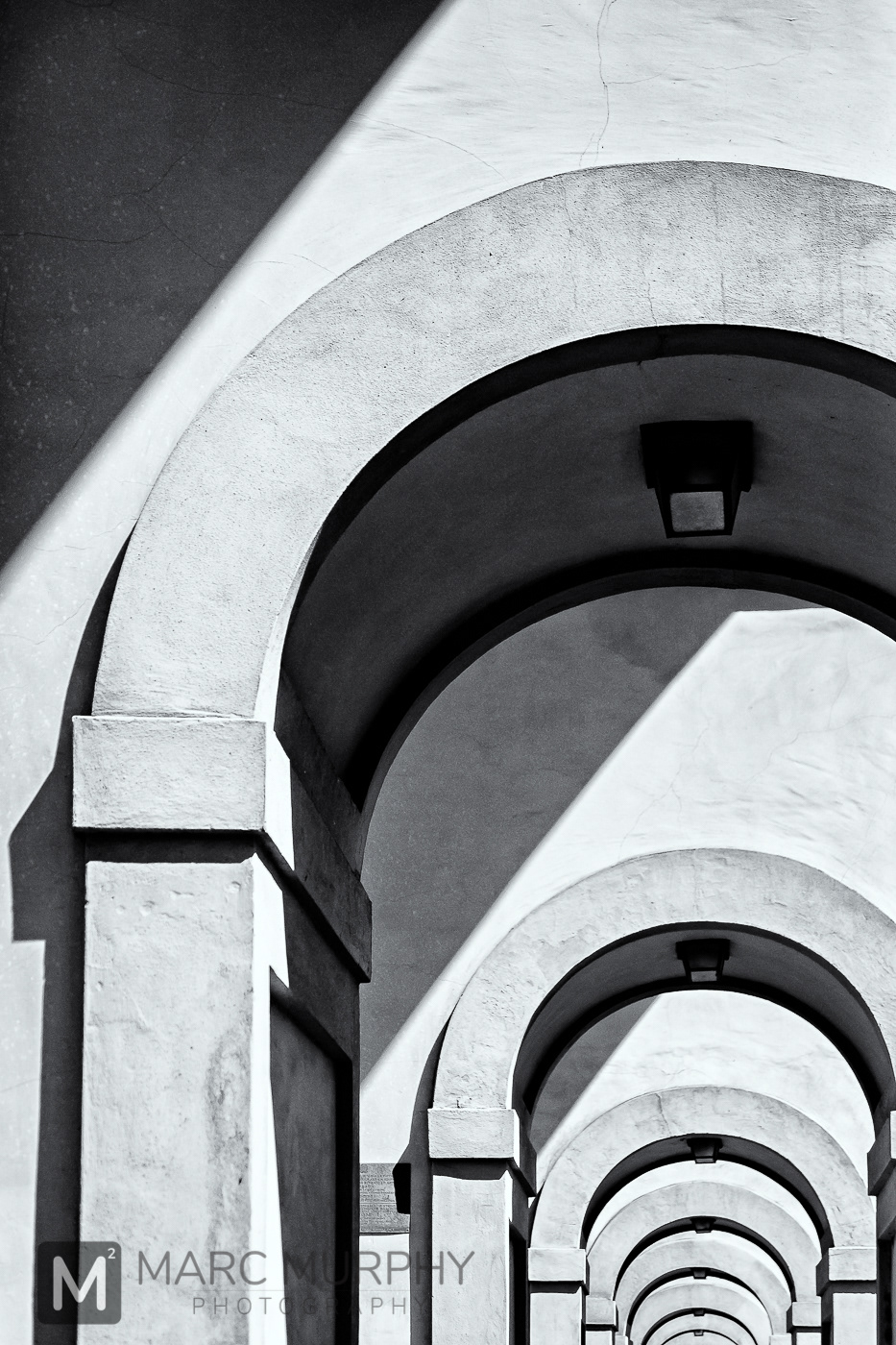 Black and White Abstract of Continuous Arched Doorways Trailing Off Down a Hallway