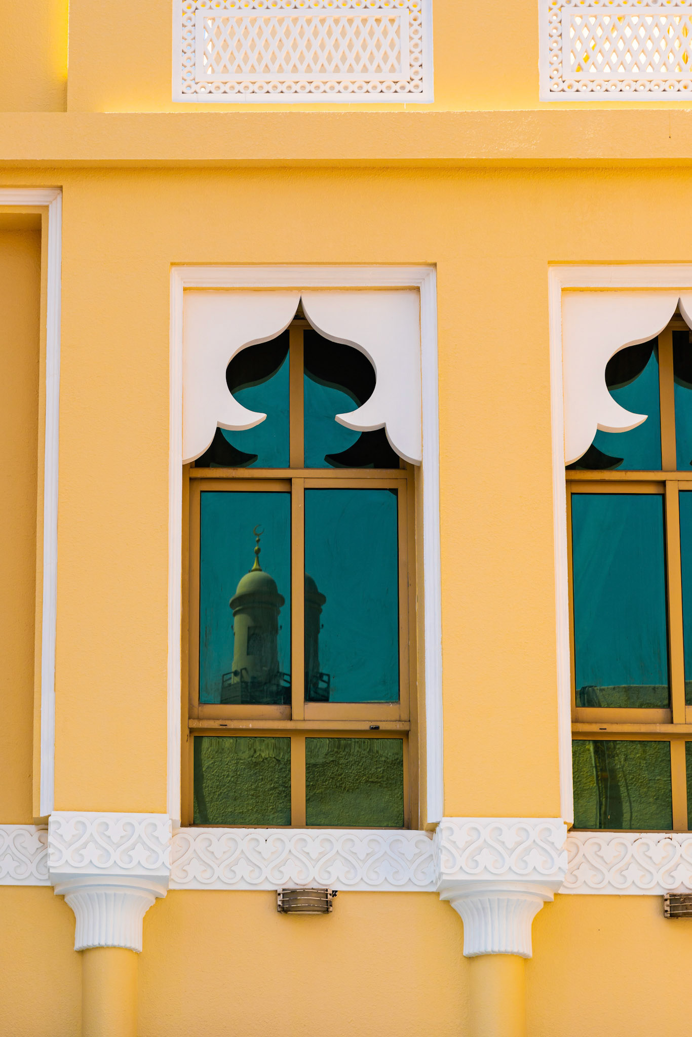 A tower is reflected in the window. Dubai details.
