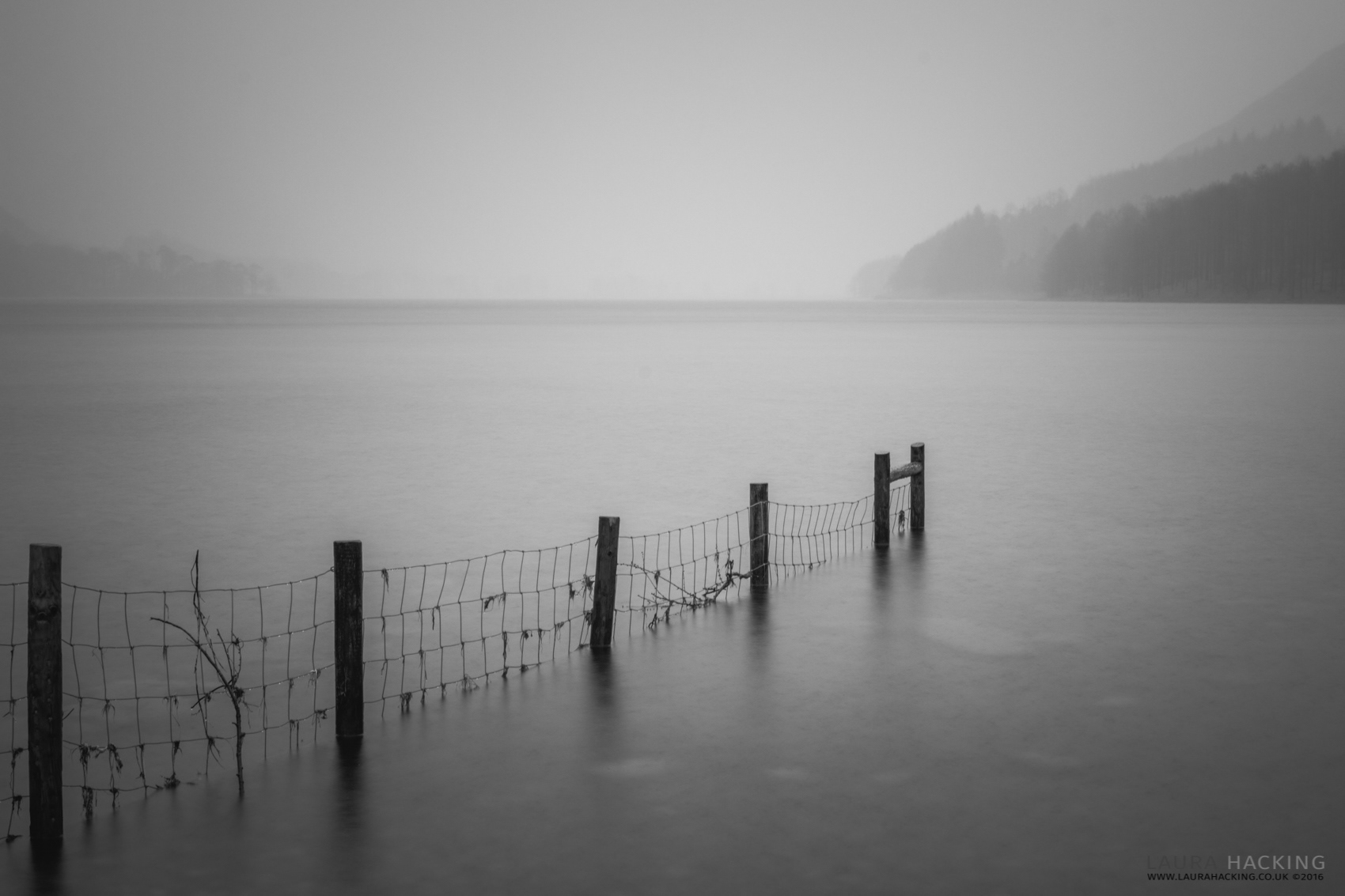 The rain falls on a misty Buttermere Lake in the Lake District National Park, England.