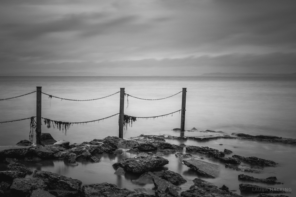 A black and white long exposure photograph of some ruined railings at Heysham, Lancashire.