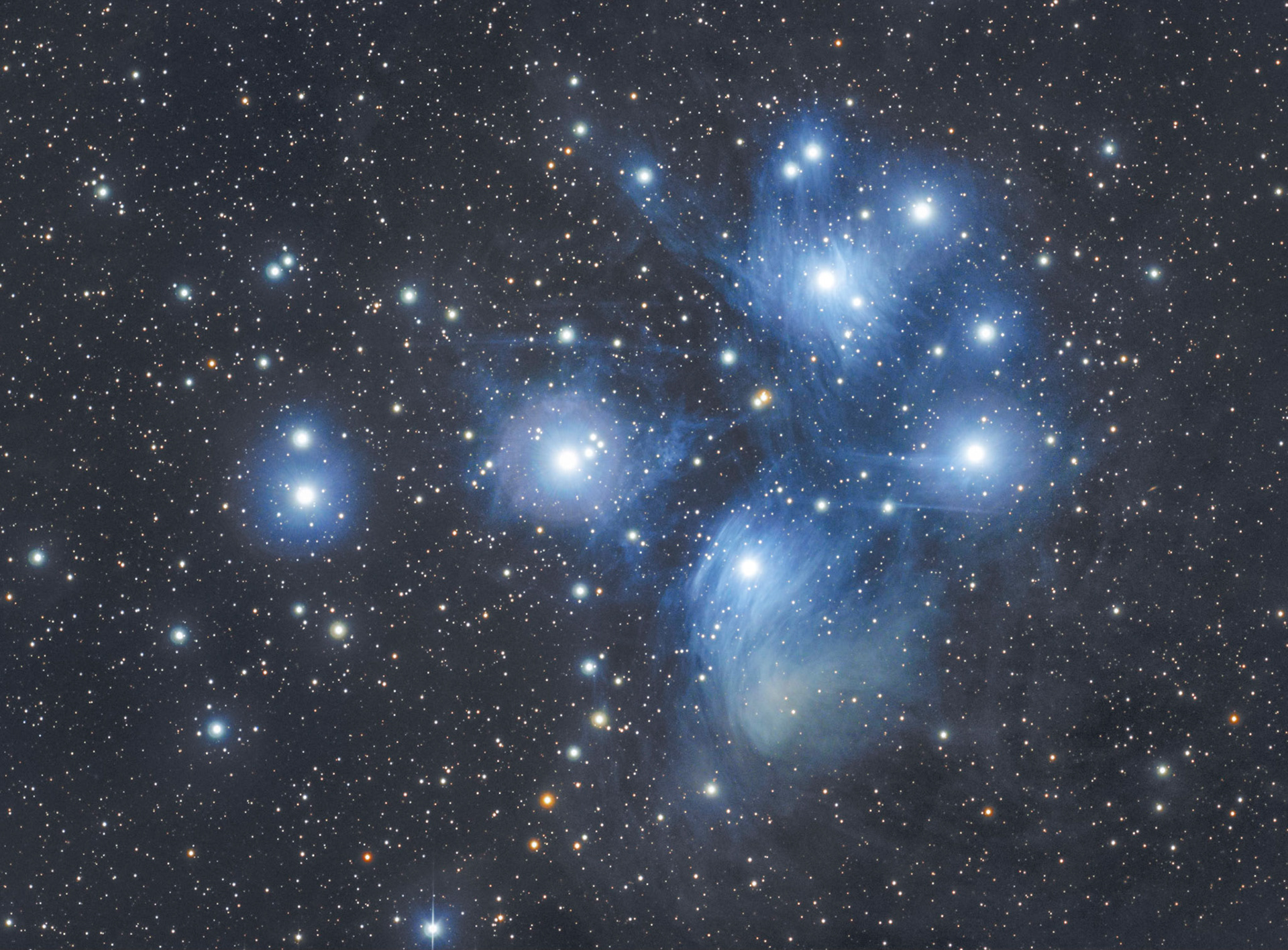 The Pleiades star clusterAlso known as the Seven Sisters and Messier 45. This star cluster is relatively close (444 light-years) and easy to spot with the naked eye (look towards the southeast after dark for a small grouping of stars). What makes this cluster so photogenic though, is that it's embedded in clouds of dust. This is most obvious near the brighter stars where they shine directly on the nearby dust. If you look closely (especially in the lower right) you'll see that the dust clouds continue, but are harder to see because they are illuminated by more distant light.