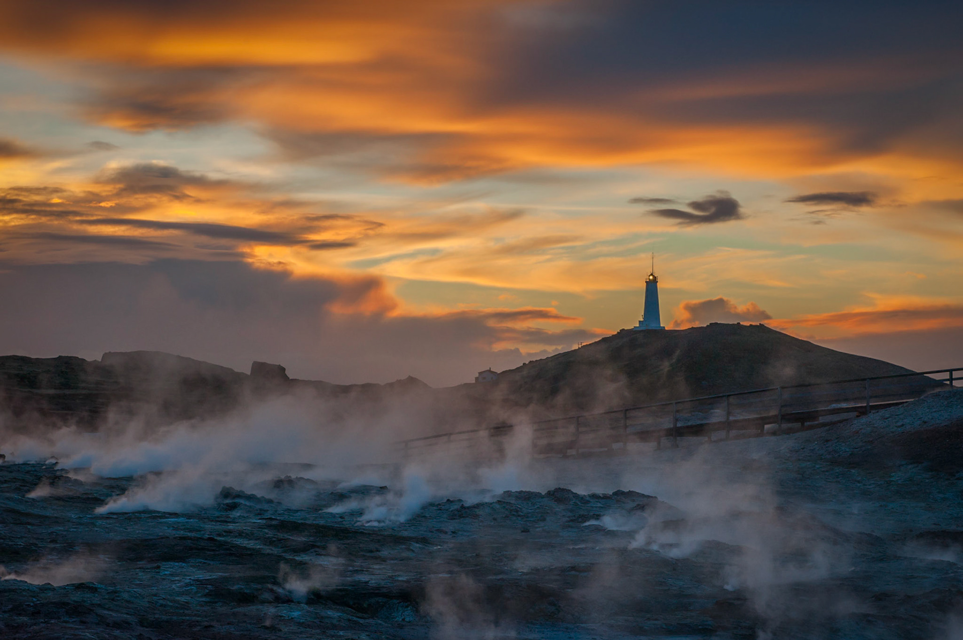 Steam rises out of the ground near a lighthouse in Reykjanesskagi (translated literally as 'smoke headland peninsula').
