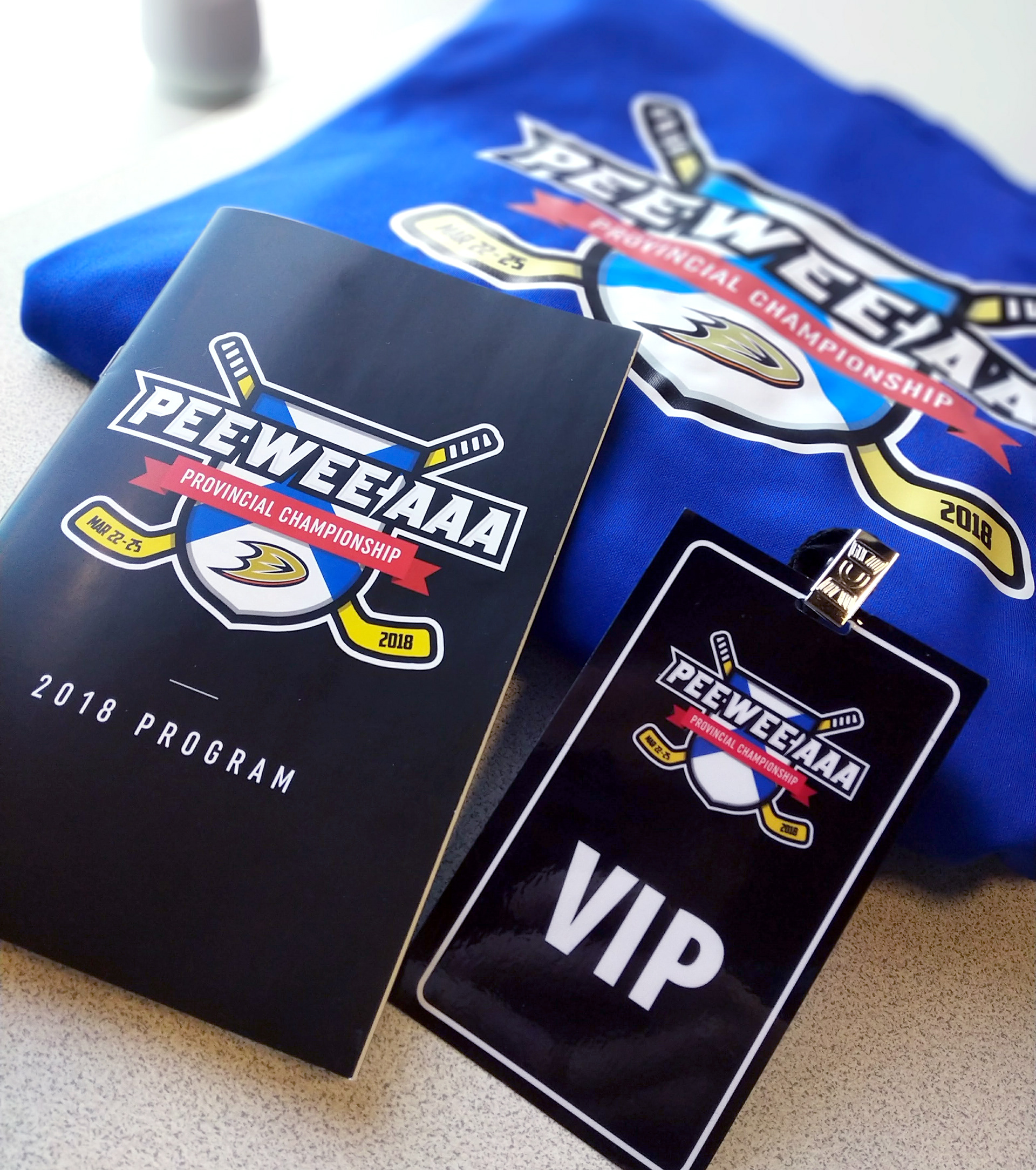 PeeWee AAA Championships collateral design including VIP badges, sweatshirts and programs.