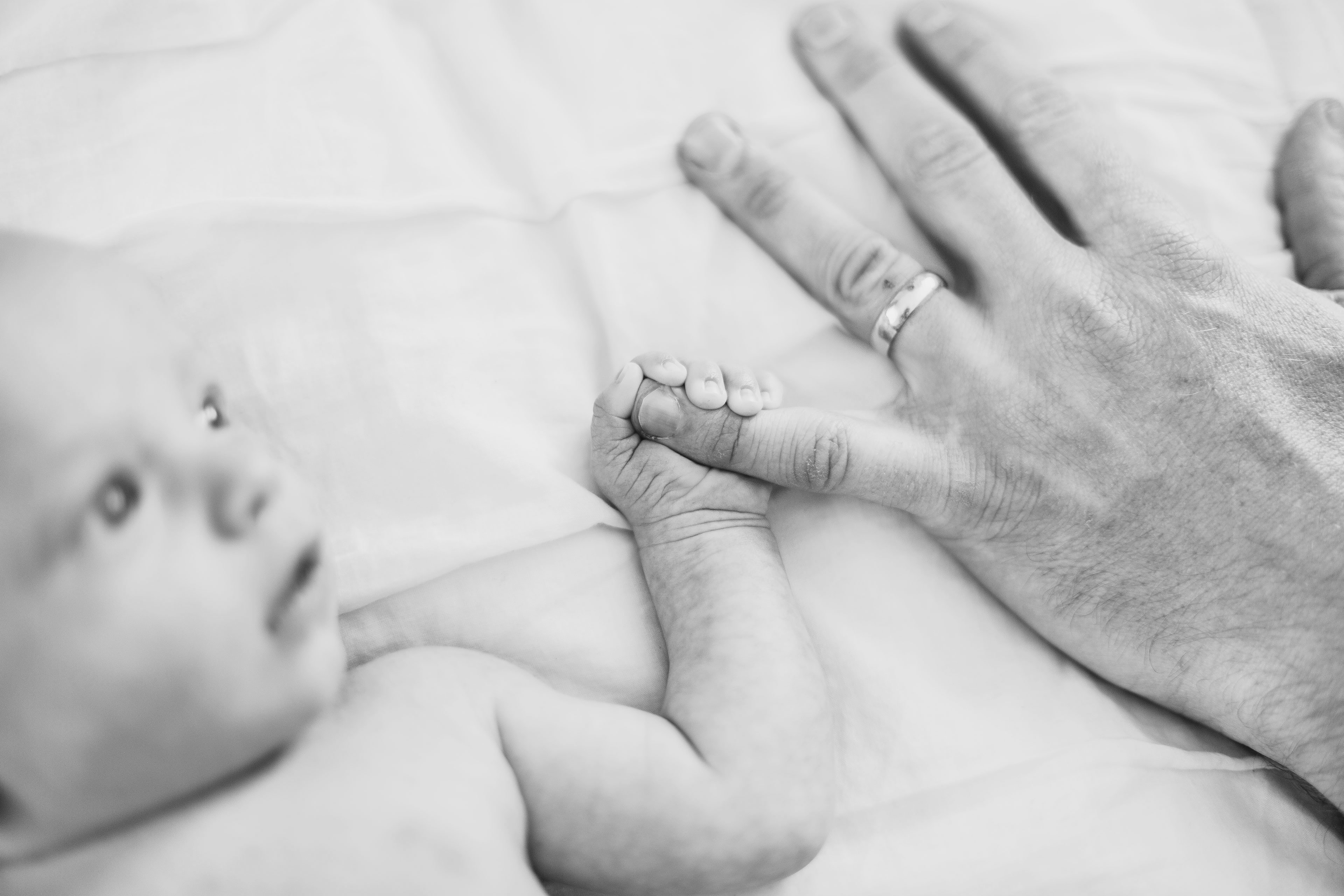 newborn boy holding finger