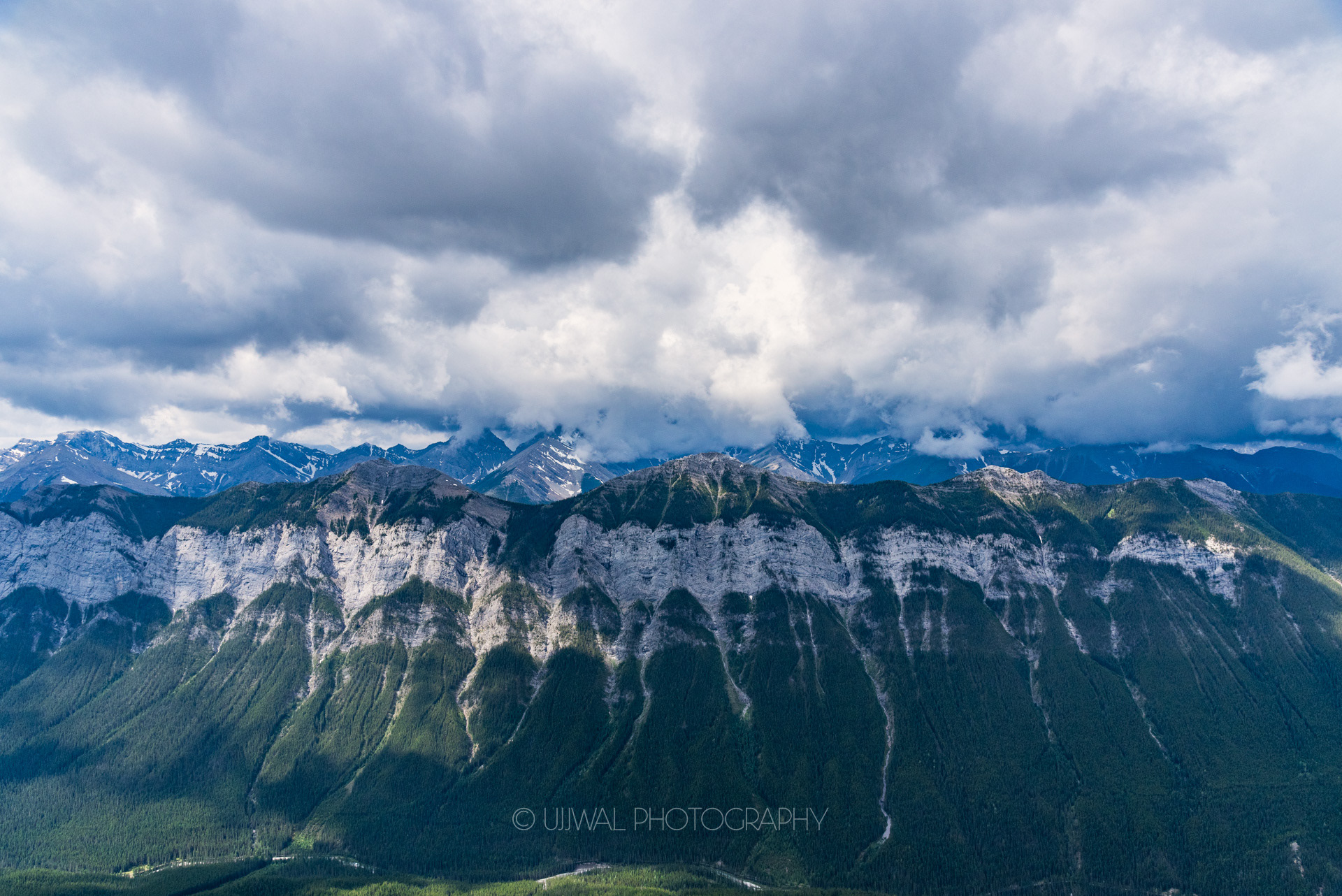 View of Clouds covering Rocky Mountains from Mount Rundle, Alberta, Canada